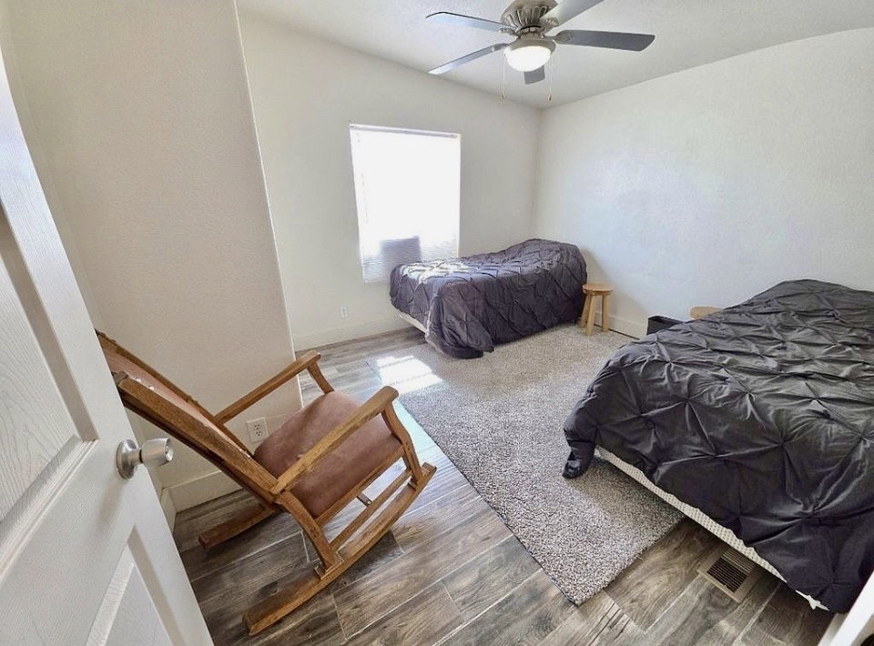 Bright room with wood-finish flooring and a central ceiling fan