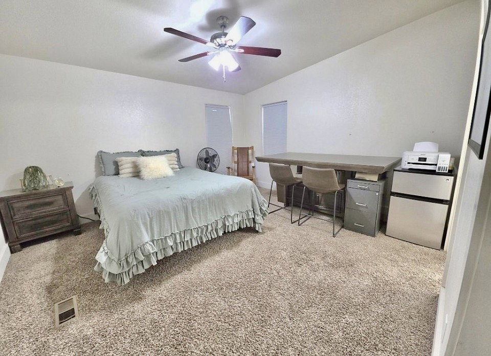 Spacious room featuring neutral carpeting and a ceiling fan