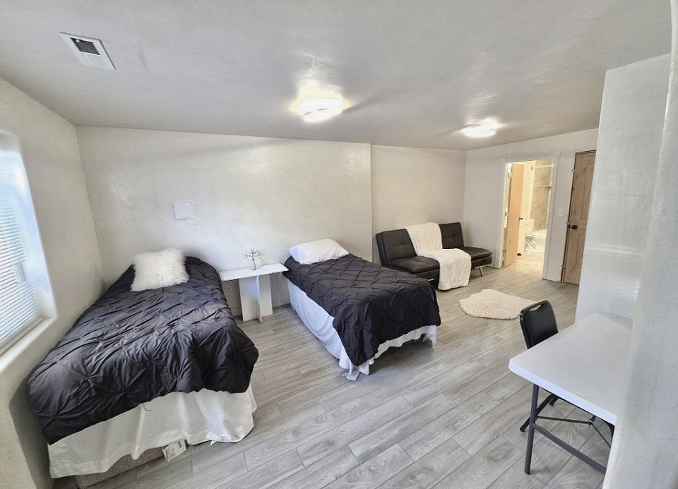 Spacious room featuring light wood-finish flooring, recessed lighting, and a window with blinds