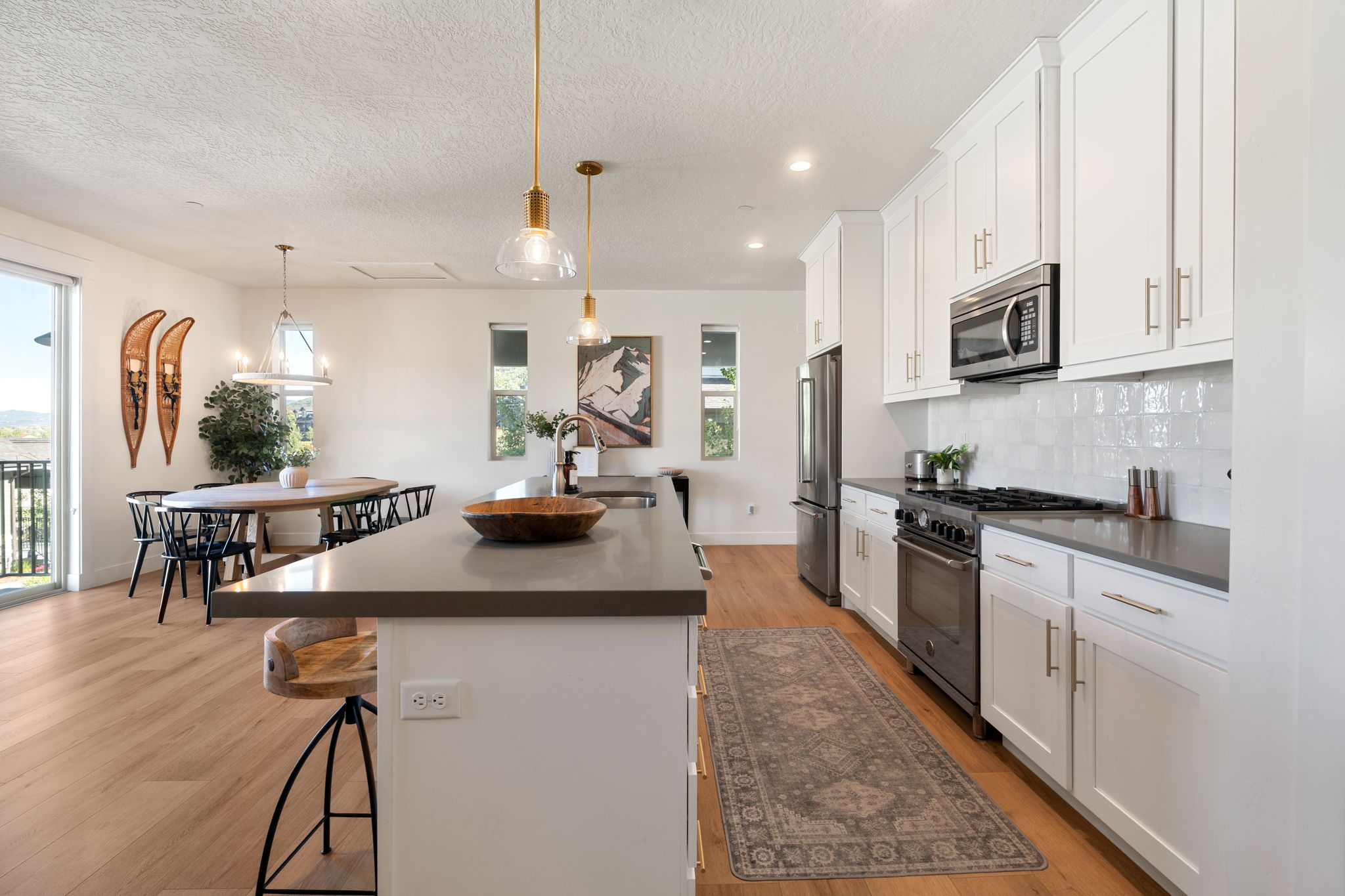 Kitchen featuring stainless steel appliances, white shaker cabinetry, dark countertops, and a white subway tile backsplash