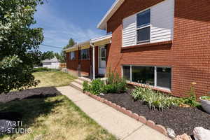 Brick exterior featuring white siding accents and a concrete pathway