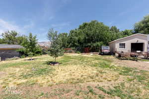 Expansive backyard featuring a detached garage with horizontal siding, a single garage bay, and a window