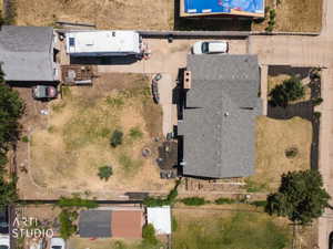 Spacious property featuring a main residence with a gray shingle roof, a detached structure with a gray shingle roof, and an expansive backyard with a fire pit
