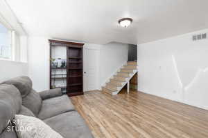 Spacious room featuring wood-finish flooring, white walls, and a recessed window