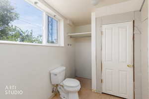 Room featuring a window, built-in shelving, white paneled door, and ceiling-mounted light fixture