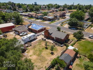 Property featuring a red brick main residence with a dark shingle roof, a red barn-style outbuilding, an additional garage structure, and a secondary smaller outbuilding with a multi-toned roof