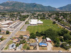 Aerial perspective showcasing residential properties within a developed neighborhood, featuring prominent mountain ranges in the background