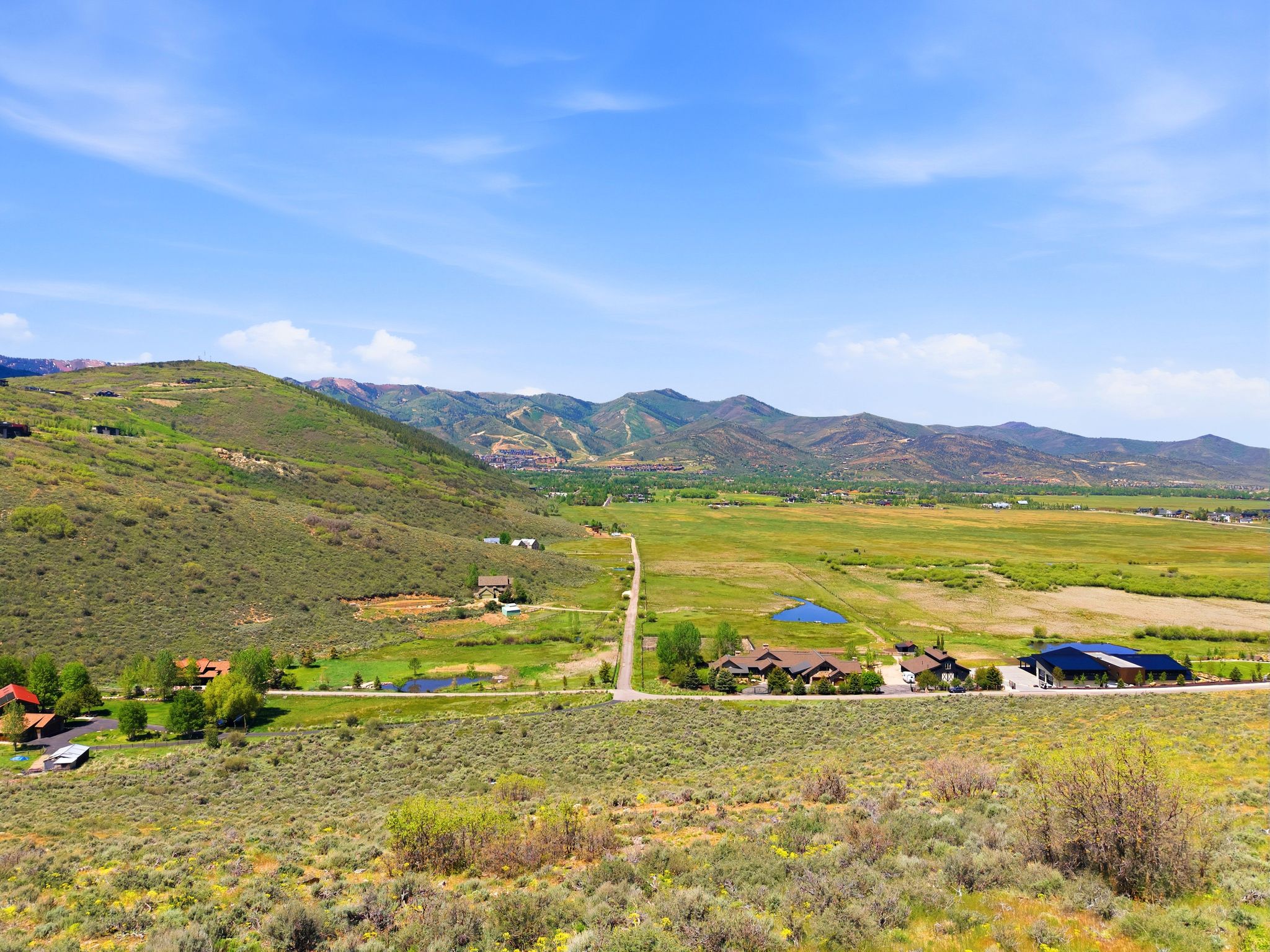 Expansive mountain landscape featuring varied terrain and multiple custom-built properties