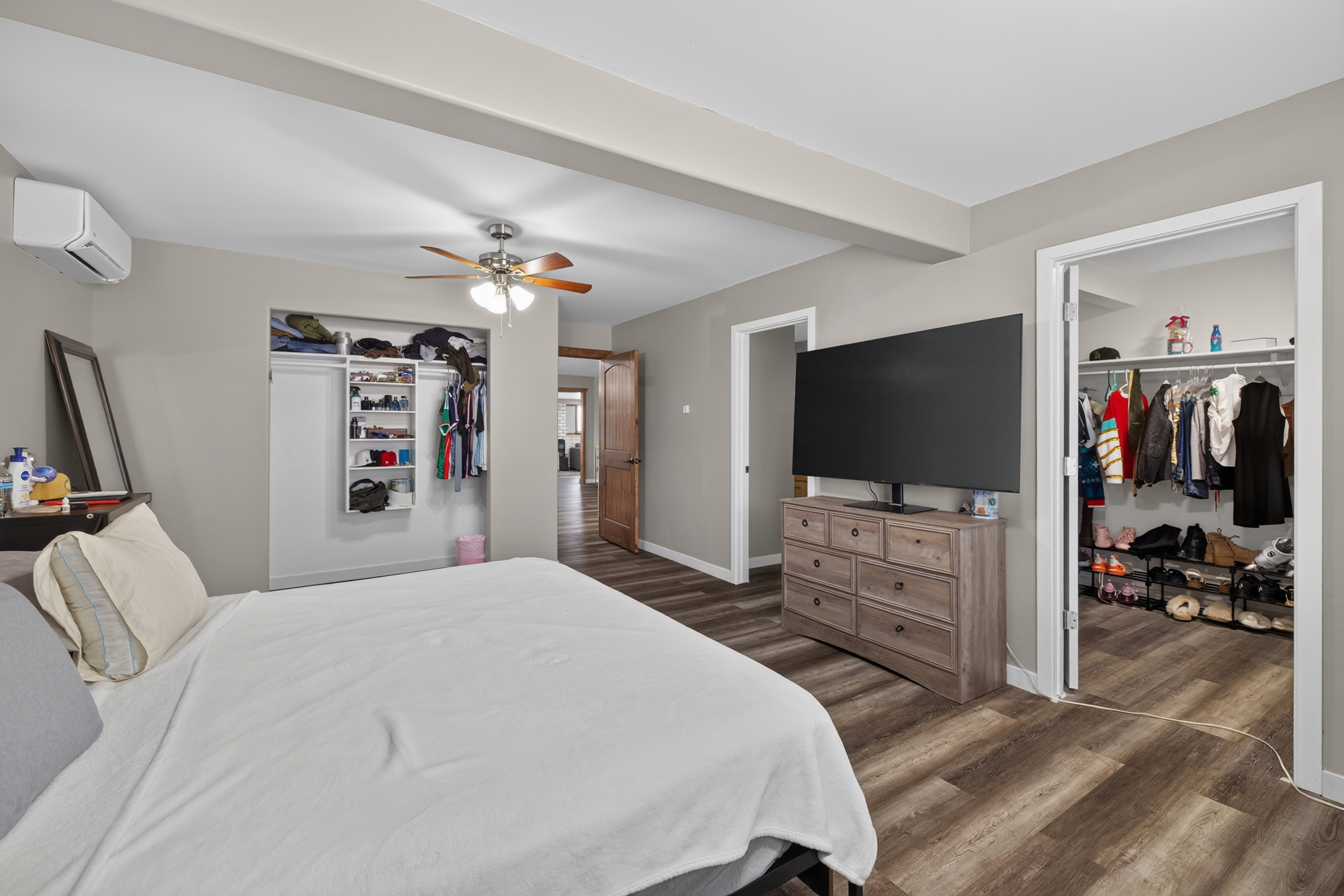 Bedroom with wood-finish flooring, a ceiling fan, and painted walls