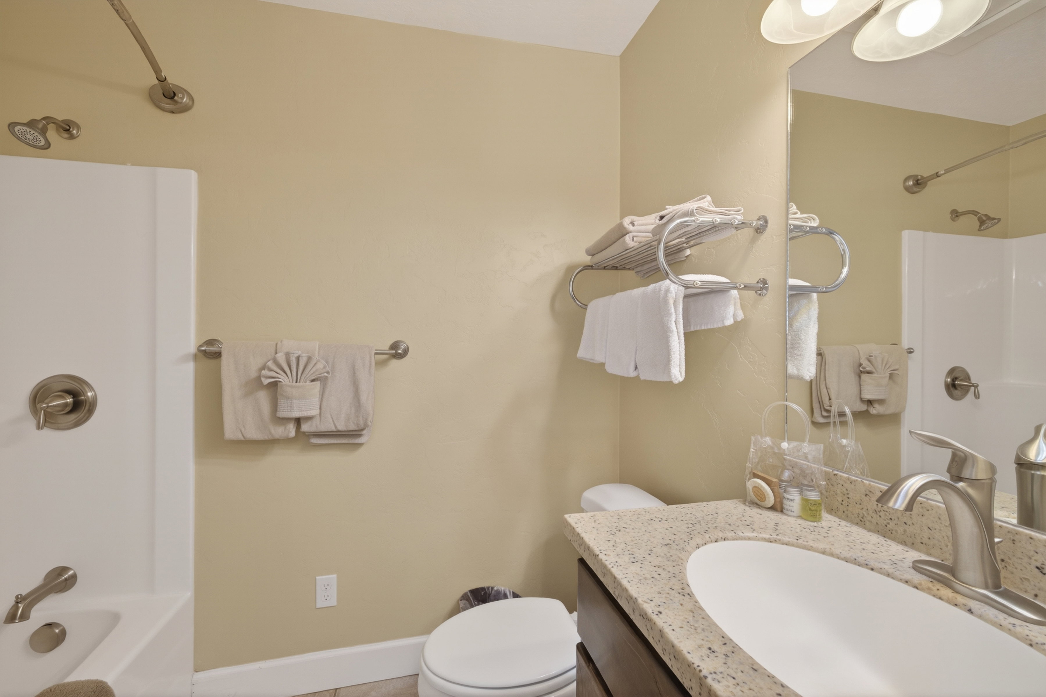 Bathroom vanity featuring a speckled countertop, undermount sink, and brushed nickel faucet