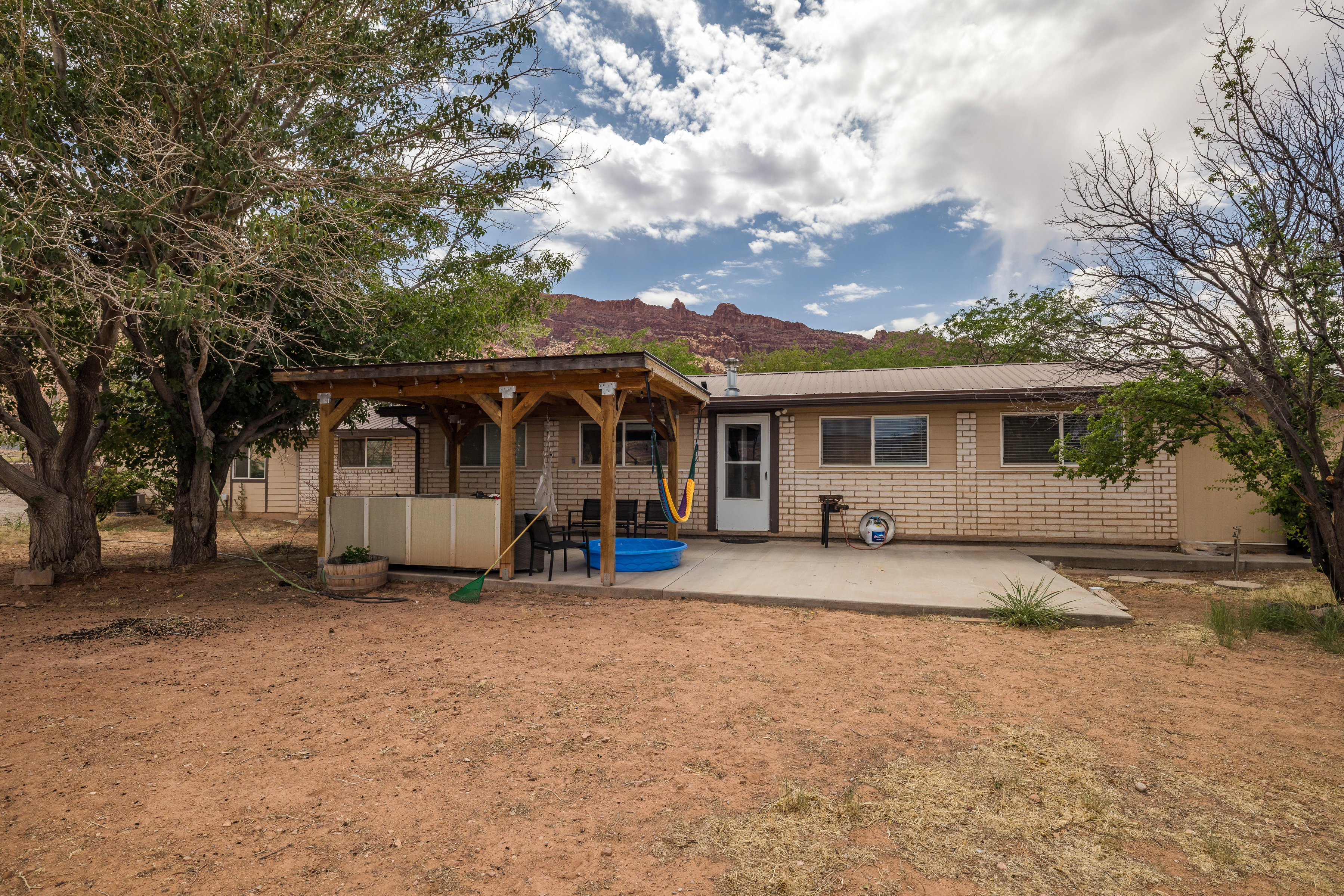 Exterior featuring a concrete patio, wood pergola, and metal roof
