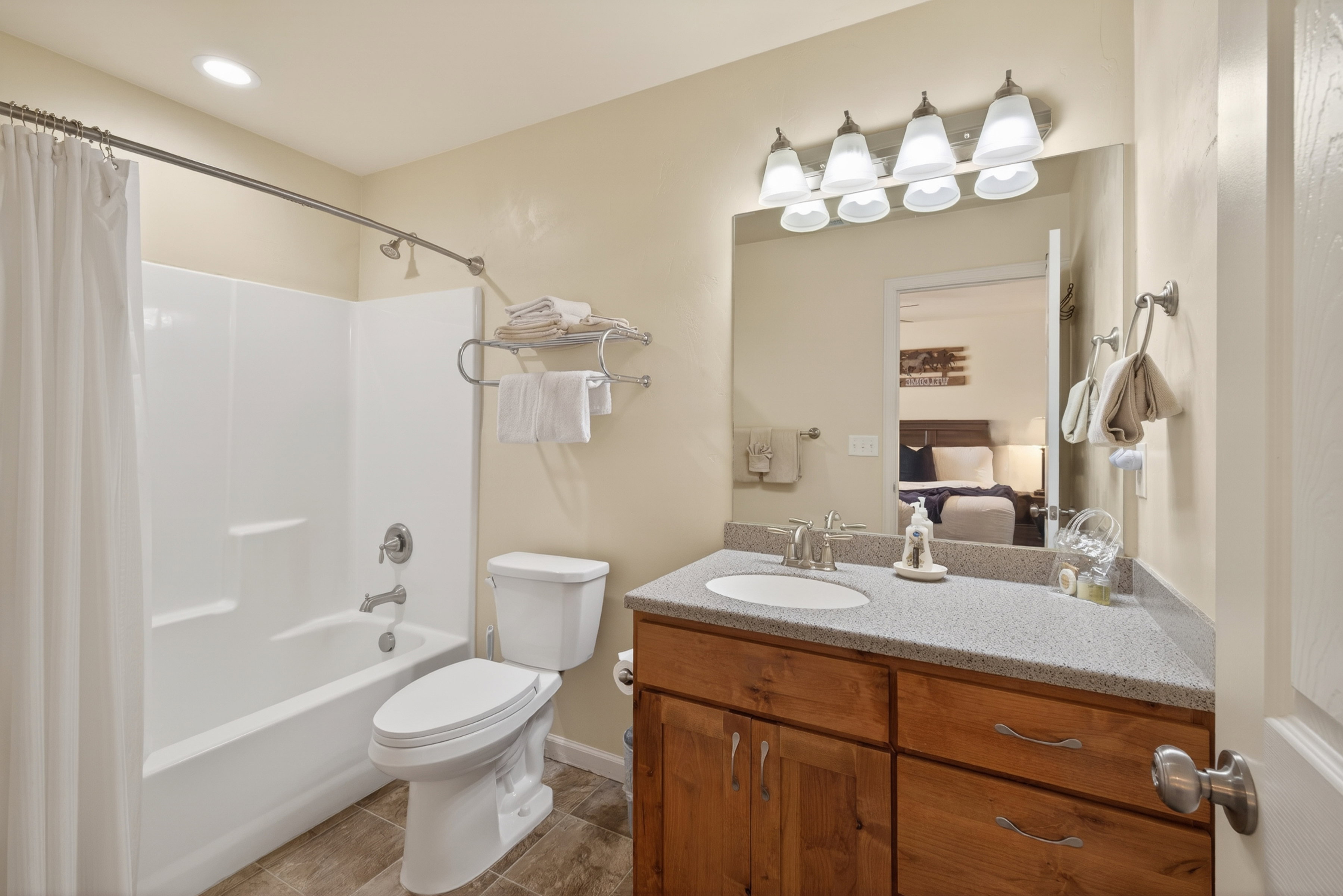 Bathroom vanity with a light-colored countertop, undermount sink, and wood-finish cabinetry