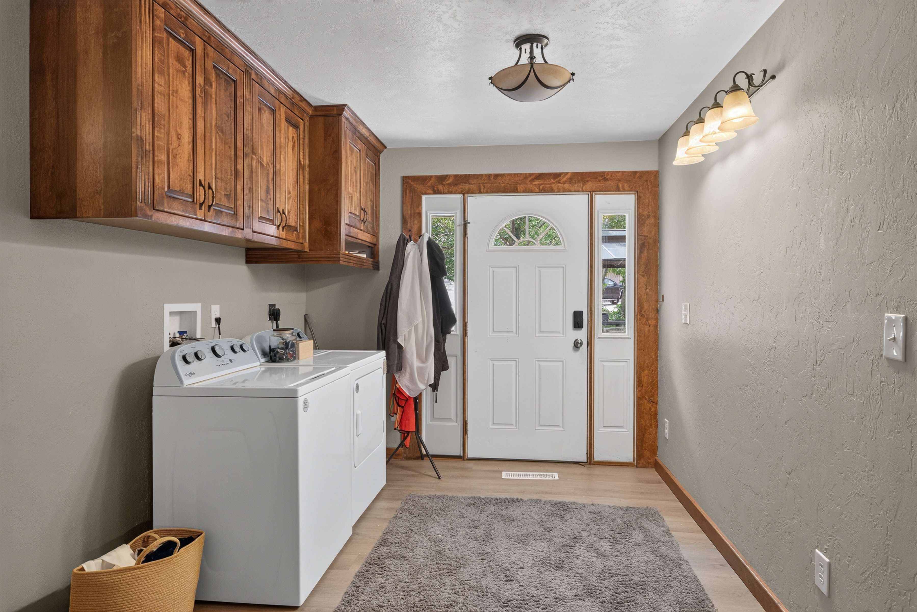 Entryway with light wood-finish flooring and a white paneled door with an arched transom window