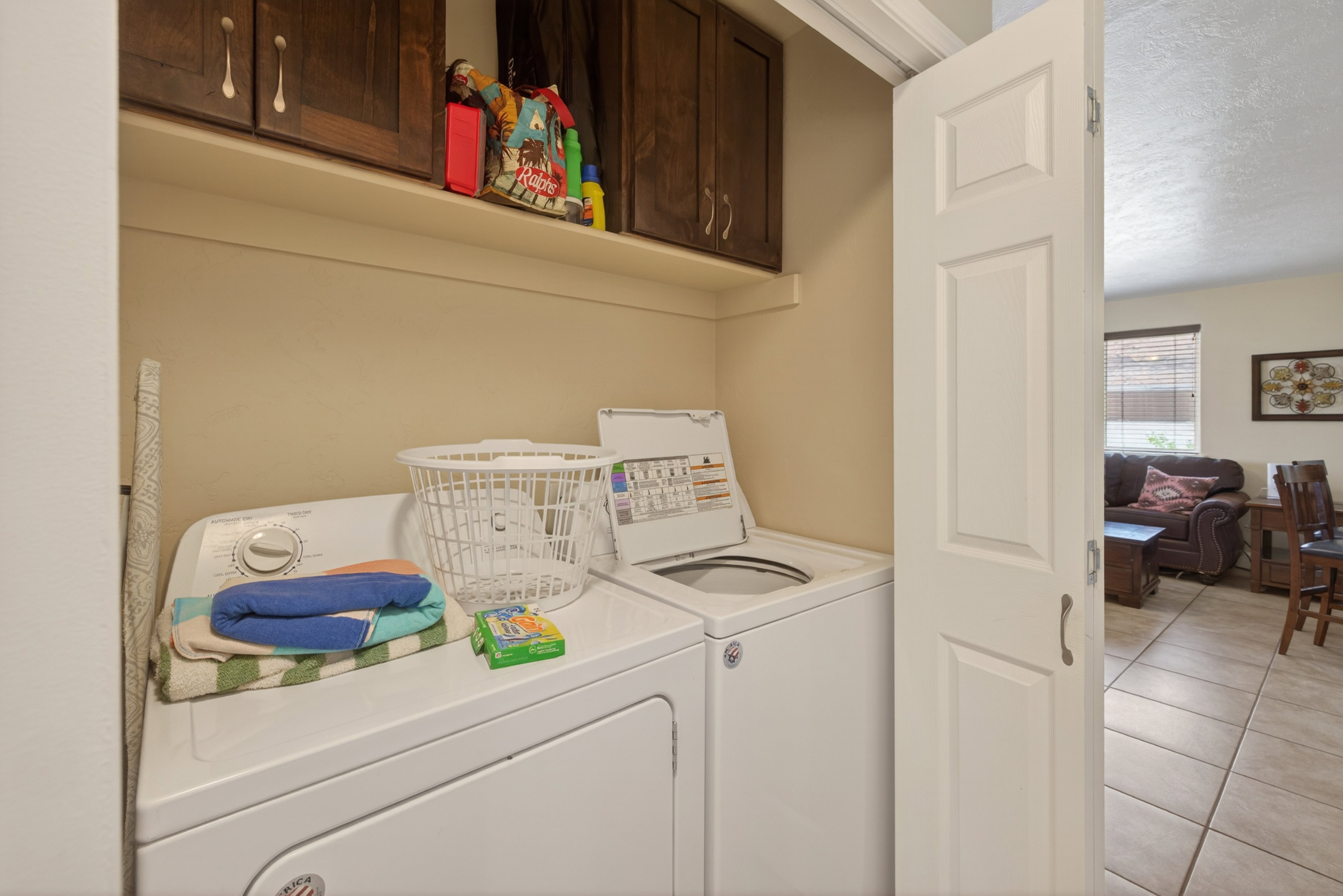 Dedicated laundry area featuring upper cabinetry and a shelf