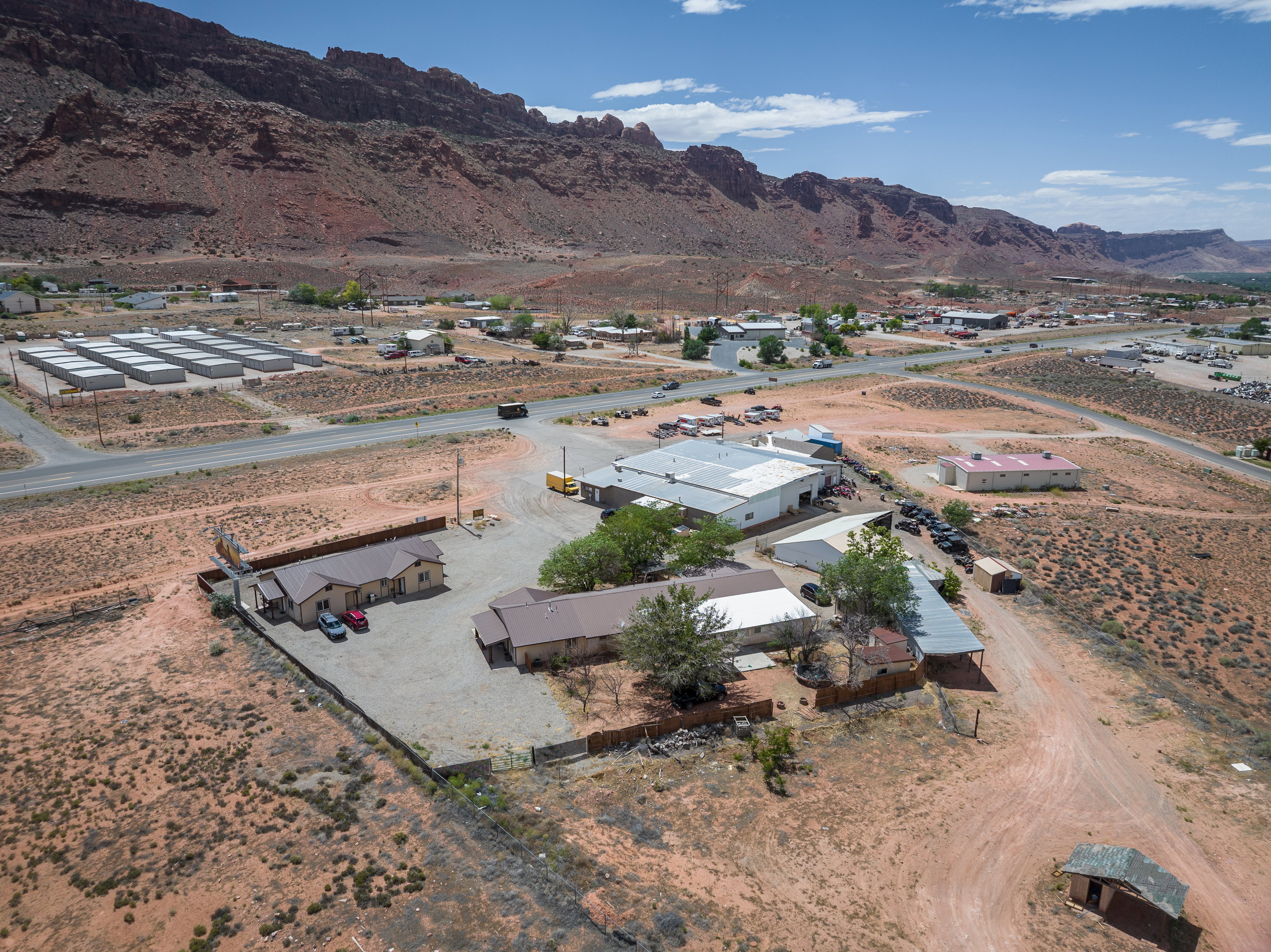Expansive desert landscape featuring multiple structures, paved roads, and a clear sky