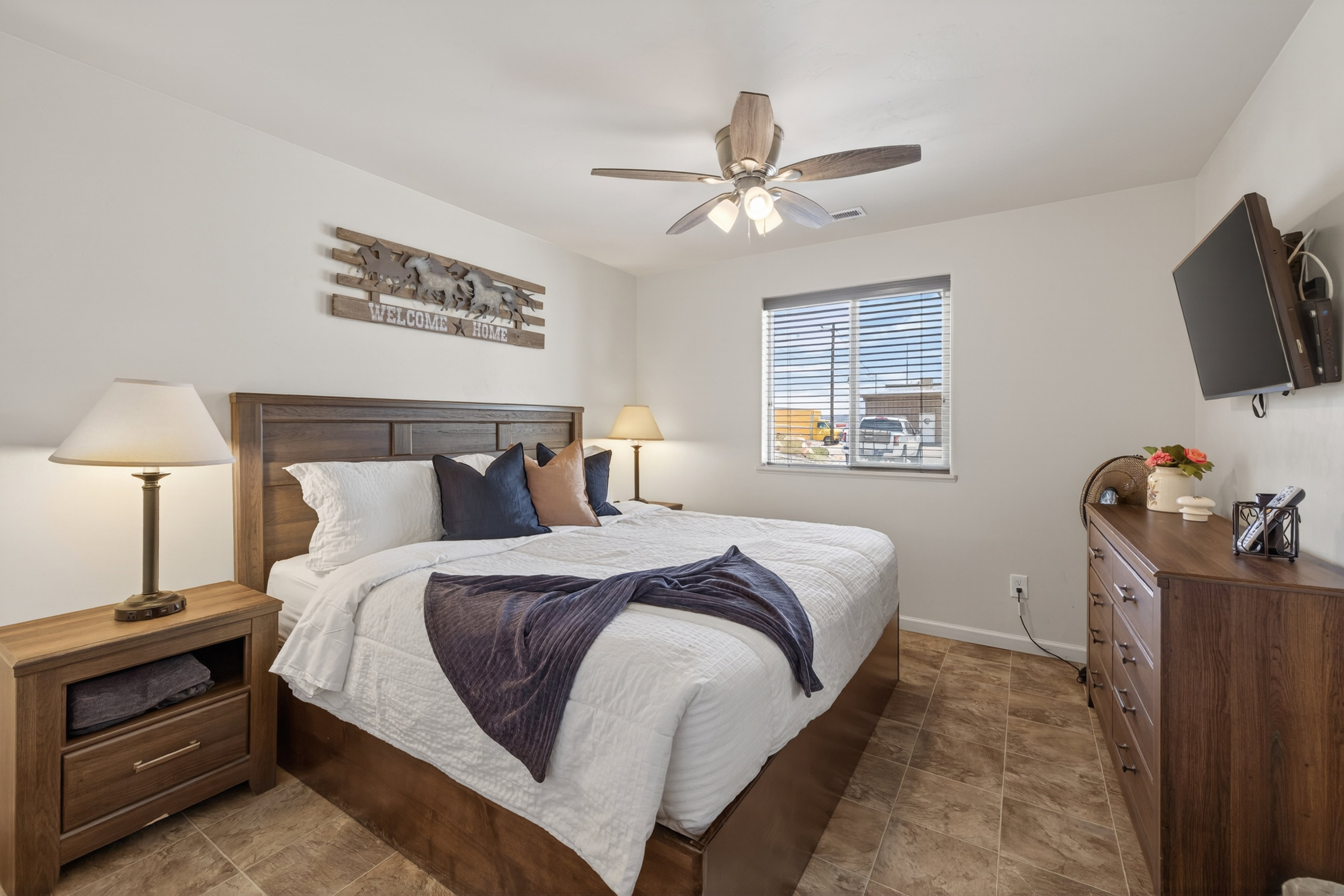 Neutral wall tones, wood-finish flooring, and a ceiling fan with integrated lighting