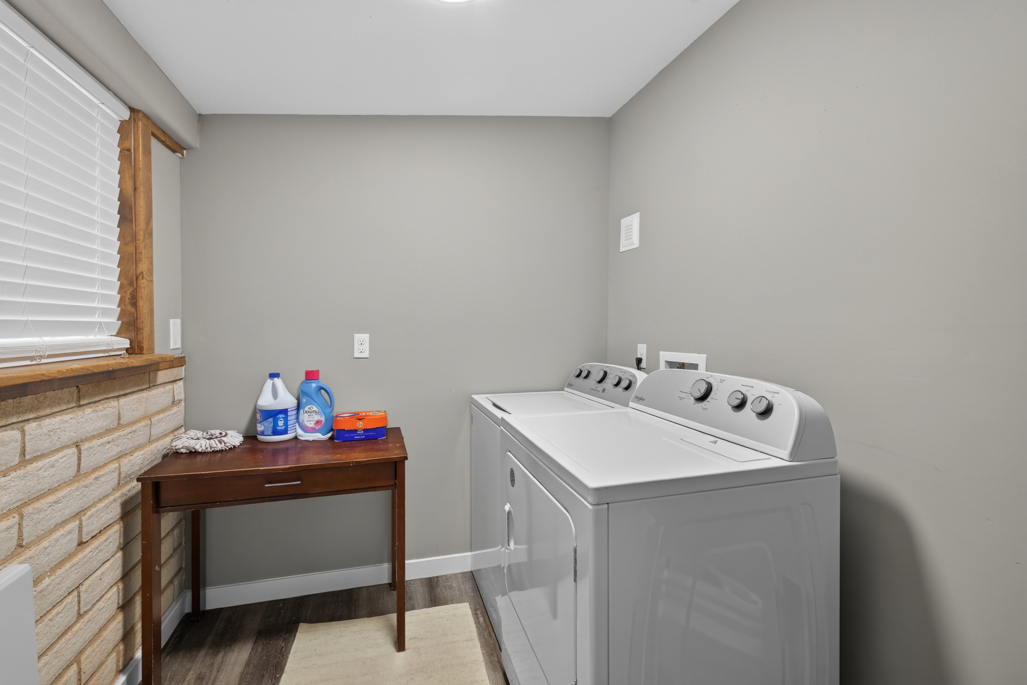 Dedicated laundry area featuring a washer and dryer, wood-finish flooring, and light gray walls
