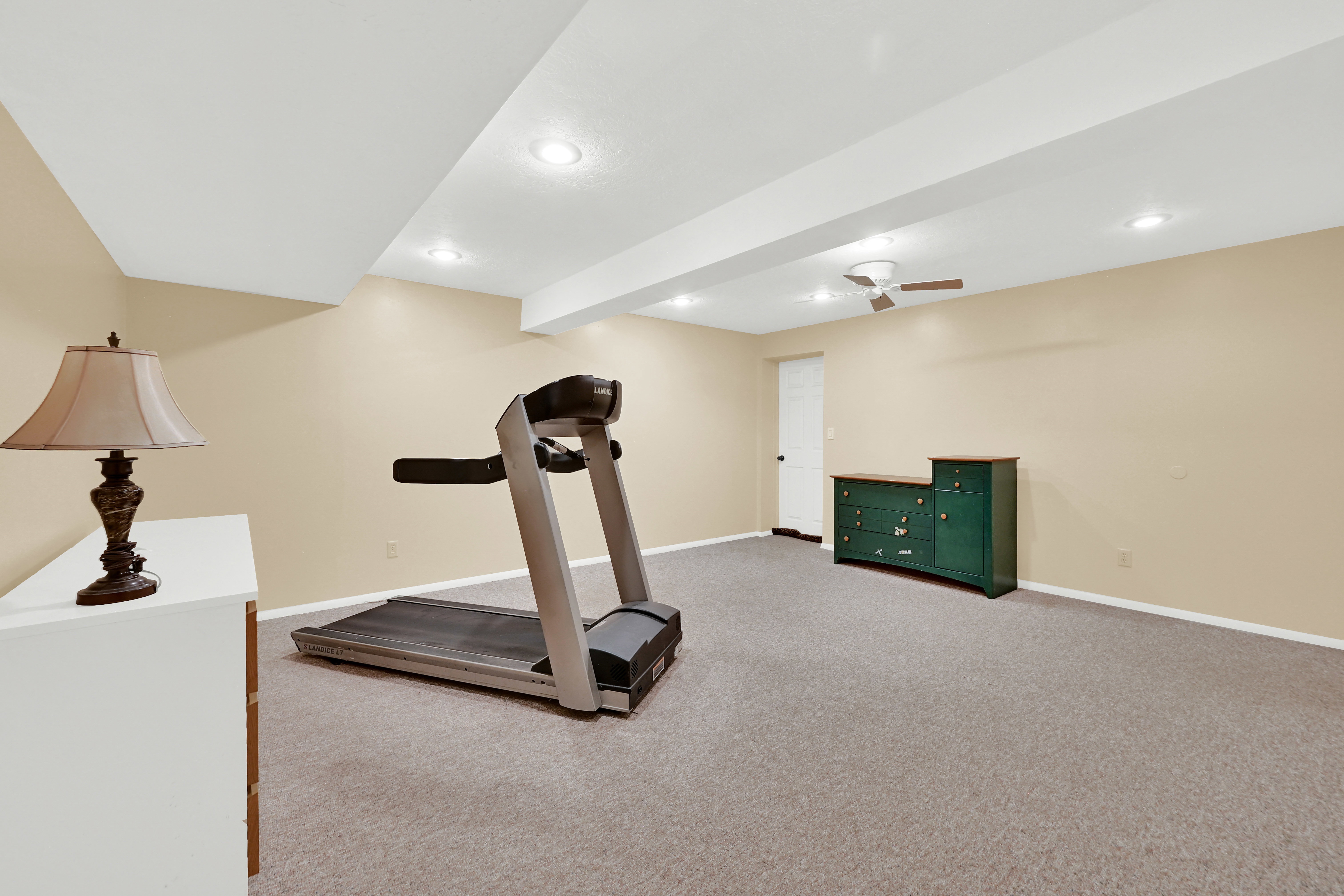 Carpeted room with recessed lighting and neutral wall tones