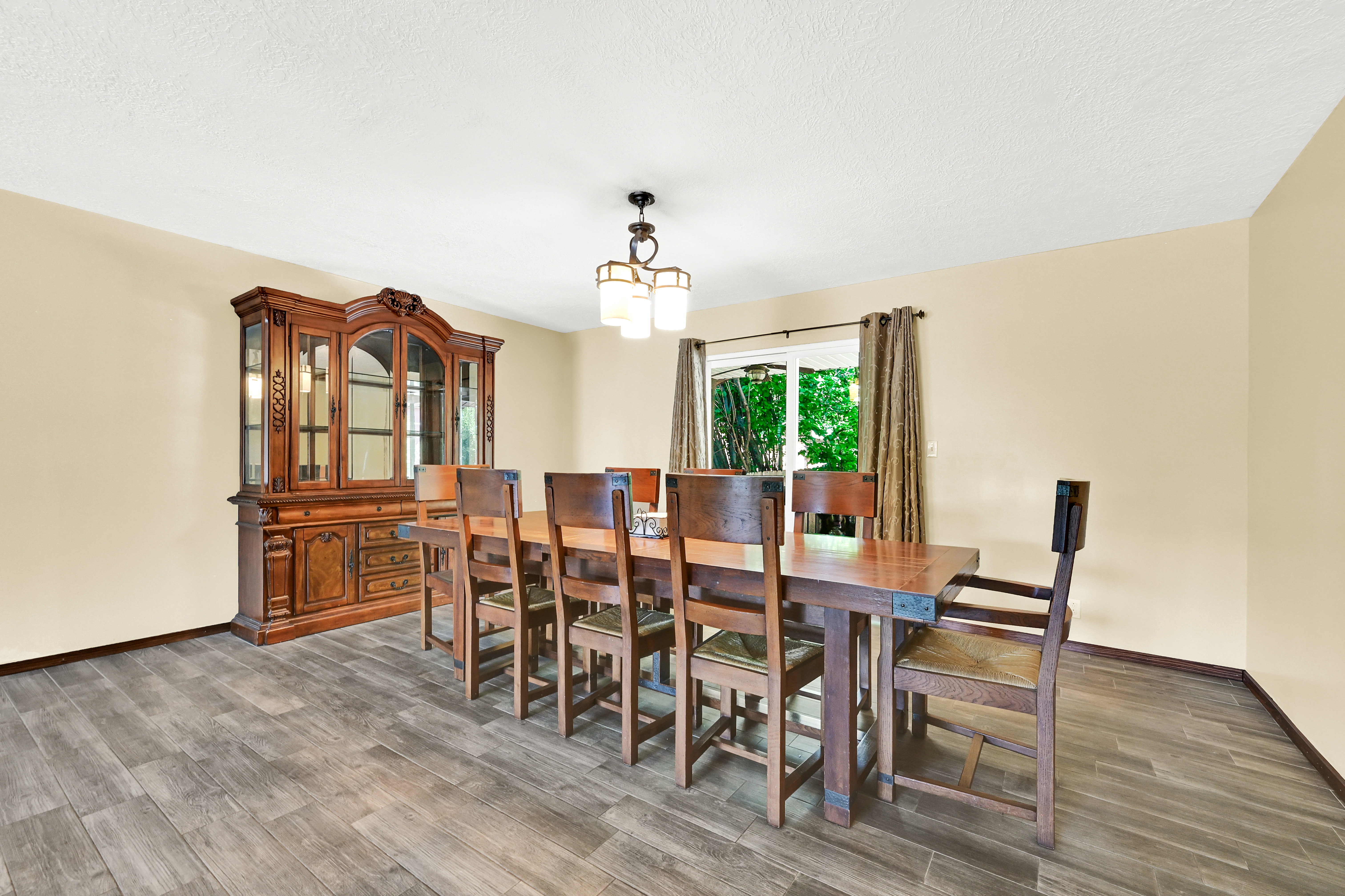 Spacious room with wood-finish flooring, light-toned walls, and a window offering natural light