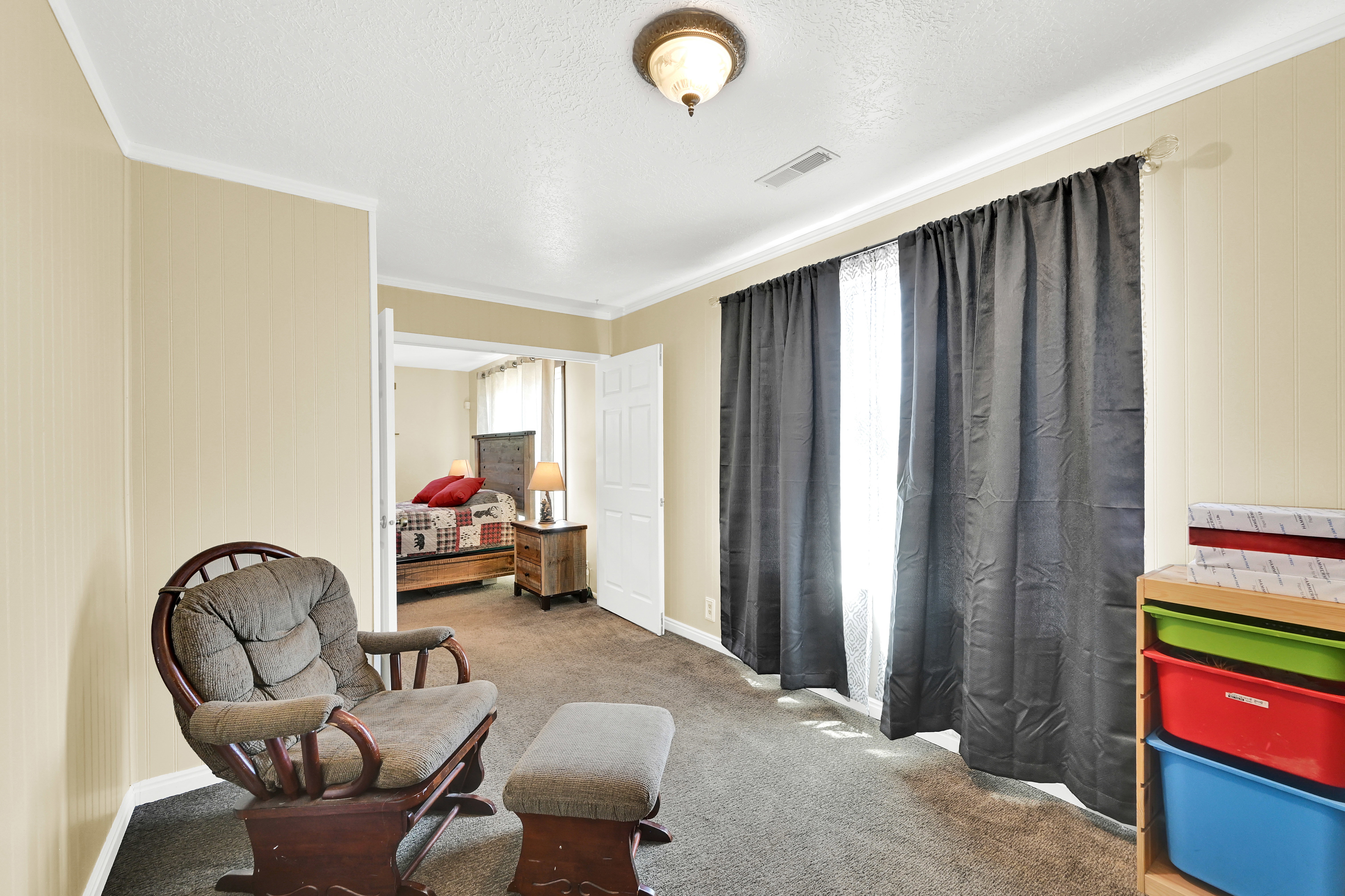 Carpeted room featuring a white ceiling, baseboards, and crown molding