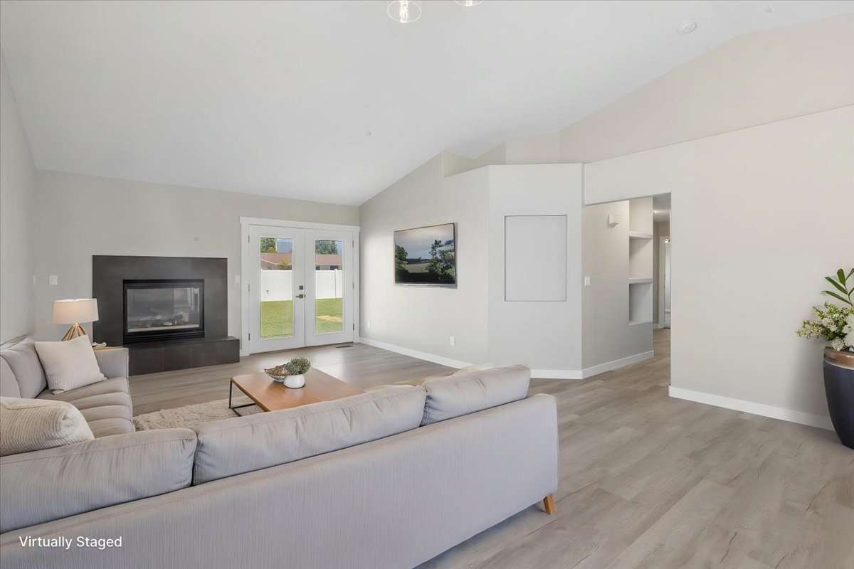 Spacious living area featuring vaulted ceilings and light wood-finish flooring