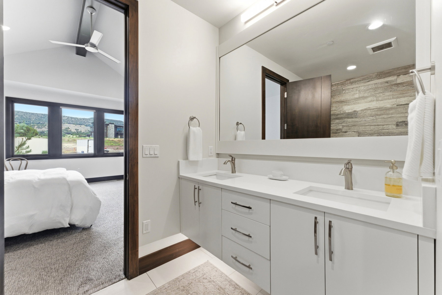 Dual vanity with integrated rectangular sinks, brushed nickel faucets, and white cabinetry with coordinating hardware