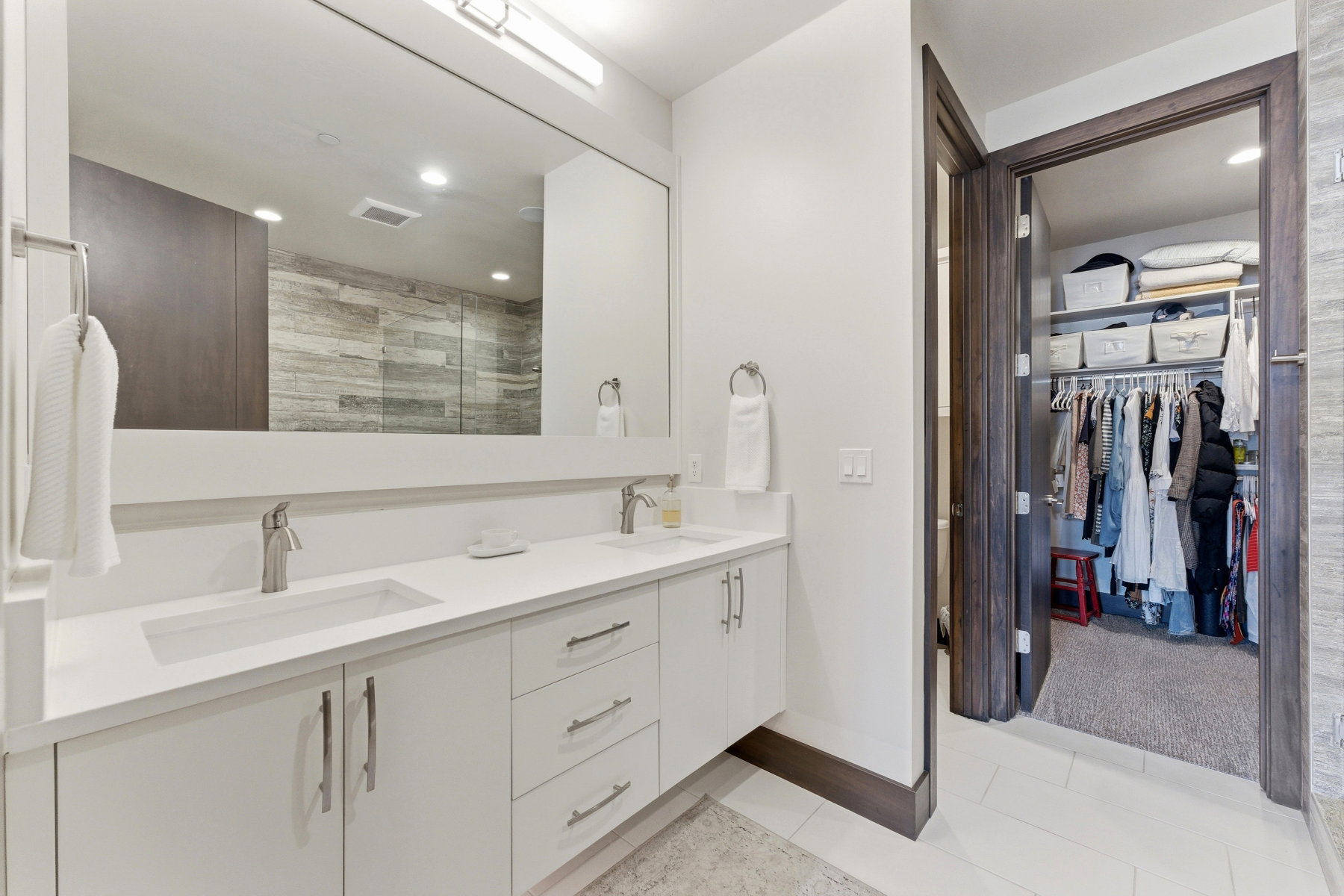 Dual vanity with integrated sinks, brushed nickel fixtures, and white cabinetry