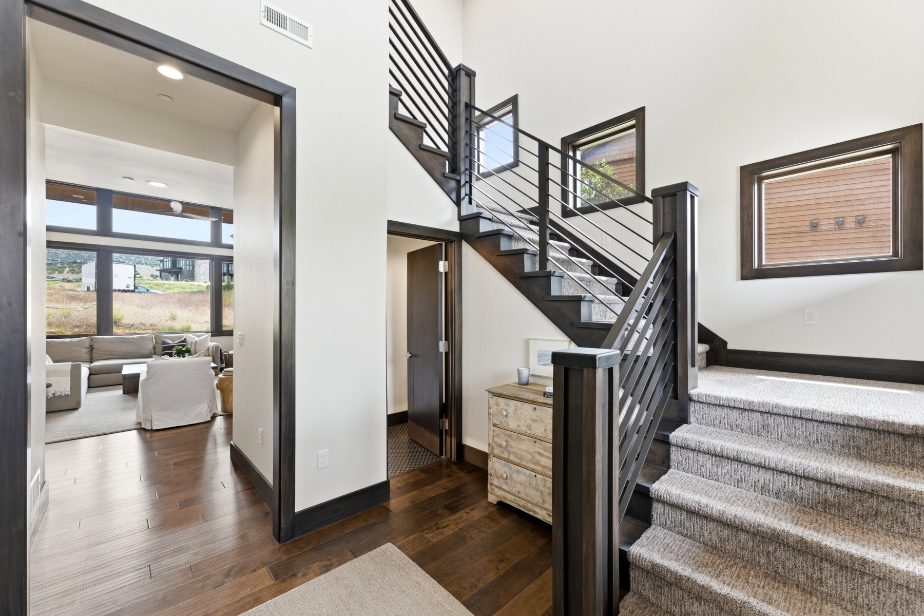 Modern staircase featuring dark wood newel posts and railings with horizontal metal balusters