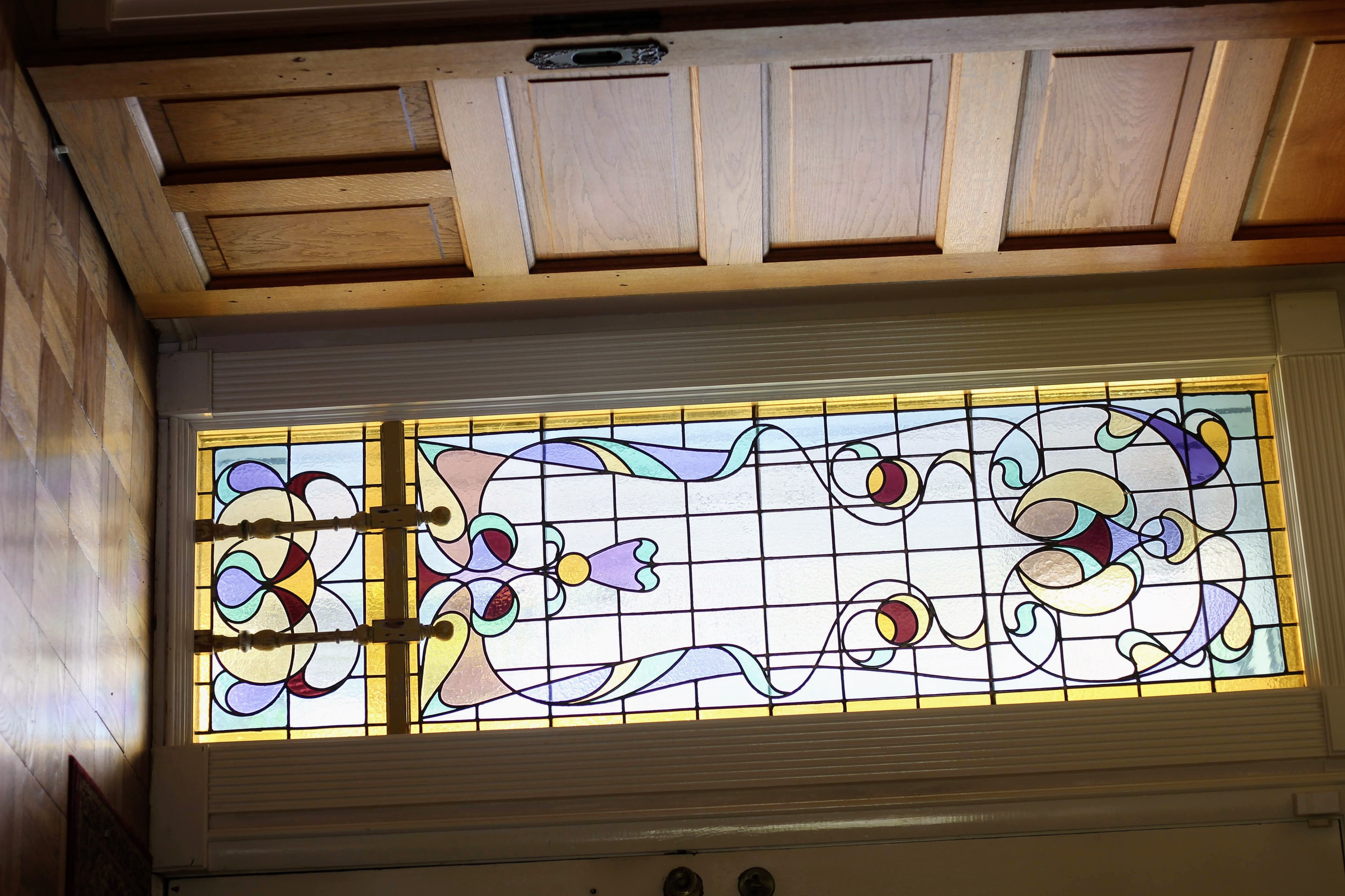 Ornate stained-glass sidelight with decorative metal grillwork