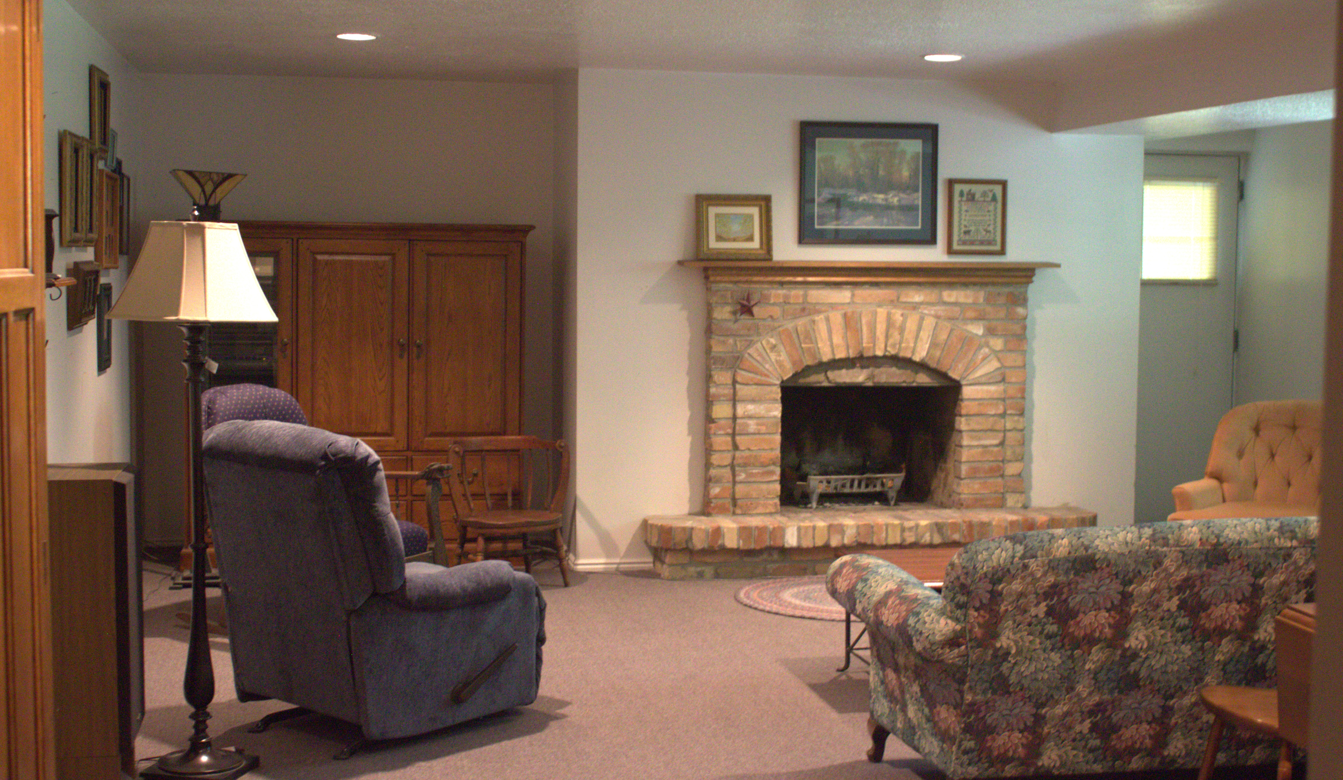 Brick-faced fireplace with a hearth and wood mantel