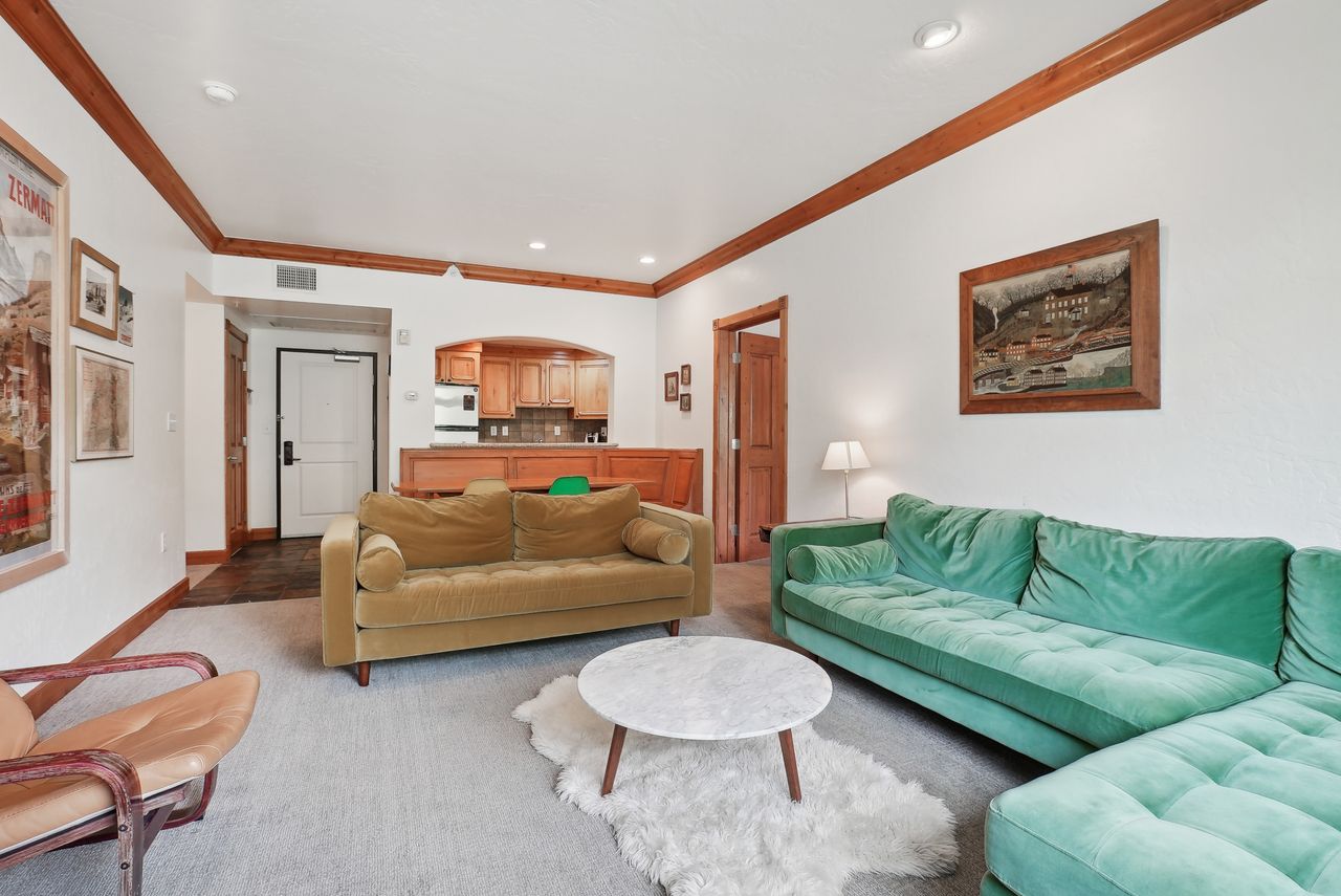 Living area featuring carpeted flooring and white walls with wood trim details