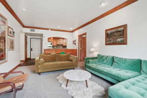 Living area featuring carpeted flooring and white walls with wood trim details