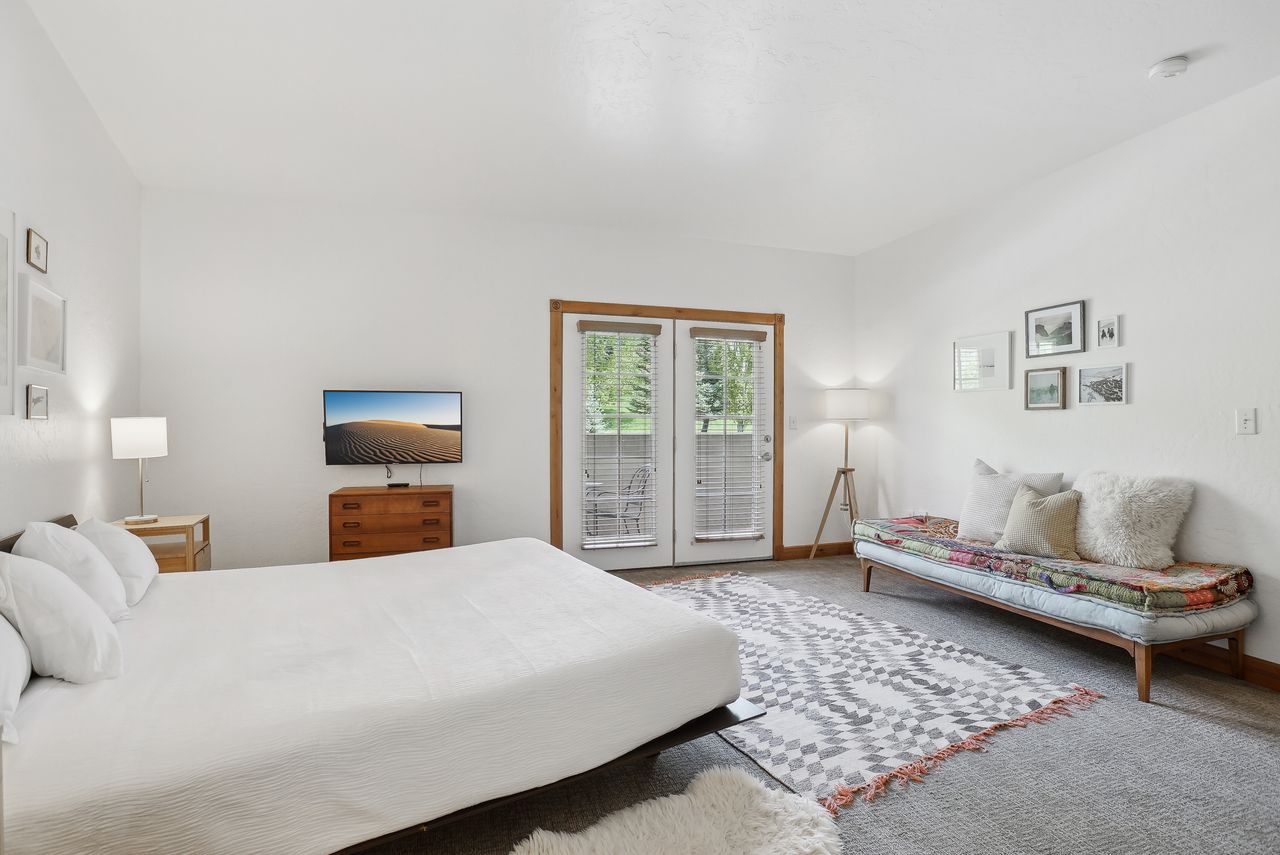 Light-filled room featuring double French doors with exterior access, wood-finish trim, and recessed lighting