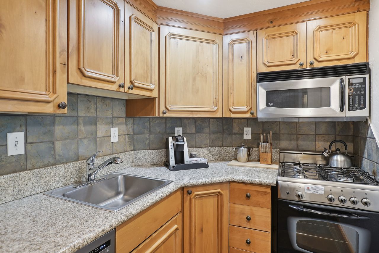 Corner kitchen with wood cabinetry and light-colored countertops