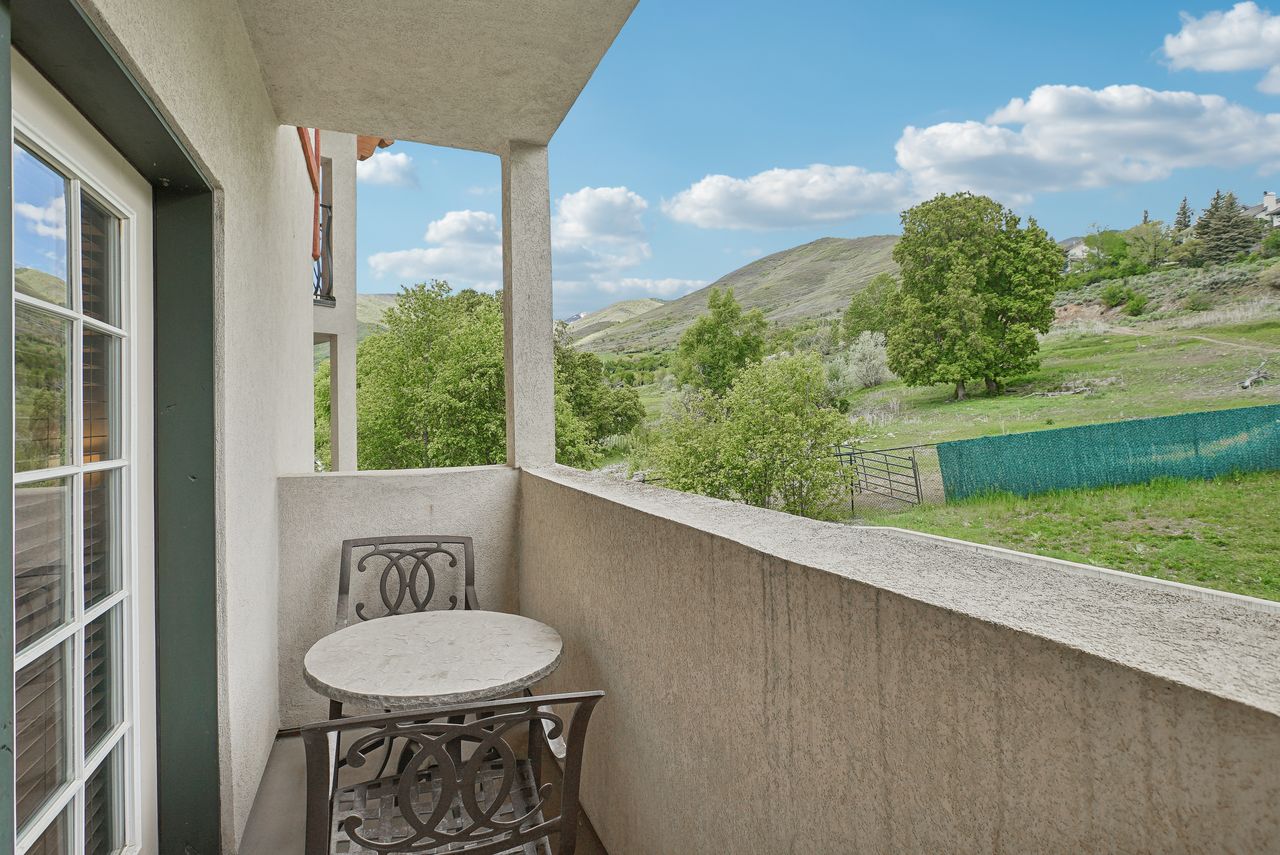 Private balcony with stucco finish and a scenic mountain backdrop