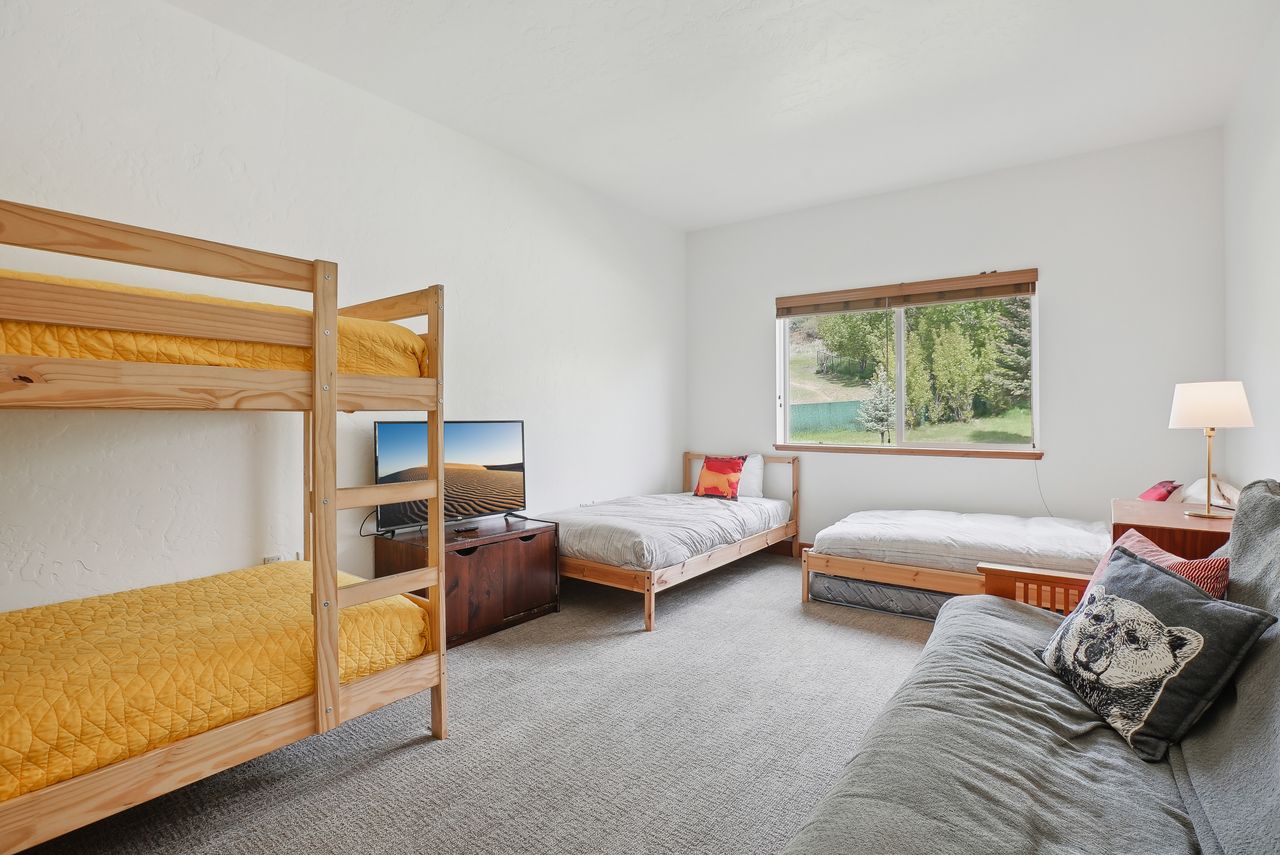 Spacious room featuring light-toned carpeting and a large window with wood-finish trim