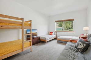 Spacious room featuring light-toned carpeting and a large window with wood-finish trim