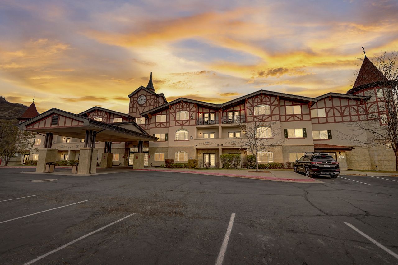 Tudor-inspired architecture featuring a prominent clock tower and a covered porte-cochère