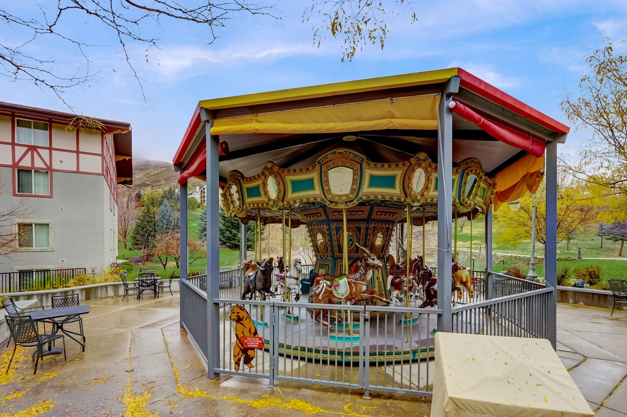 Outdoor recreational carousel featuring a decorative canopy and painted animal figures