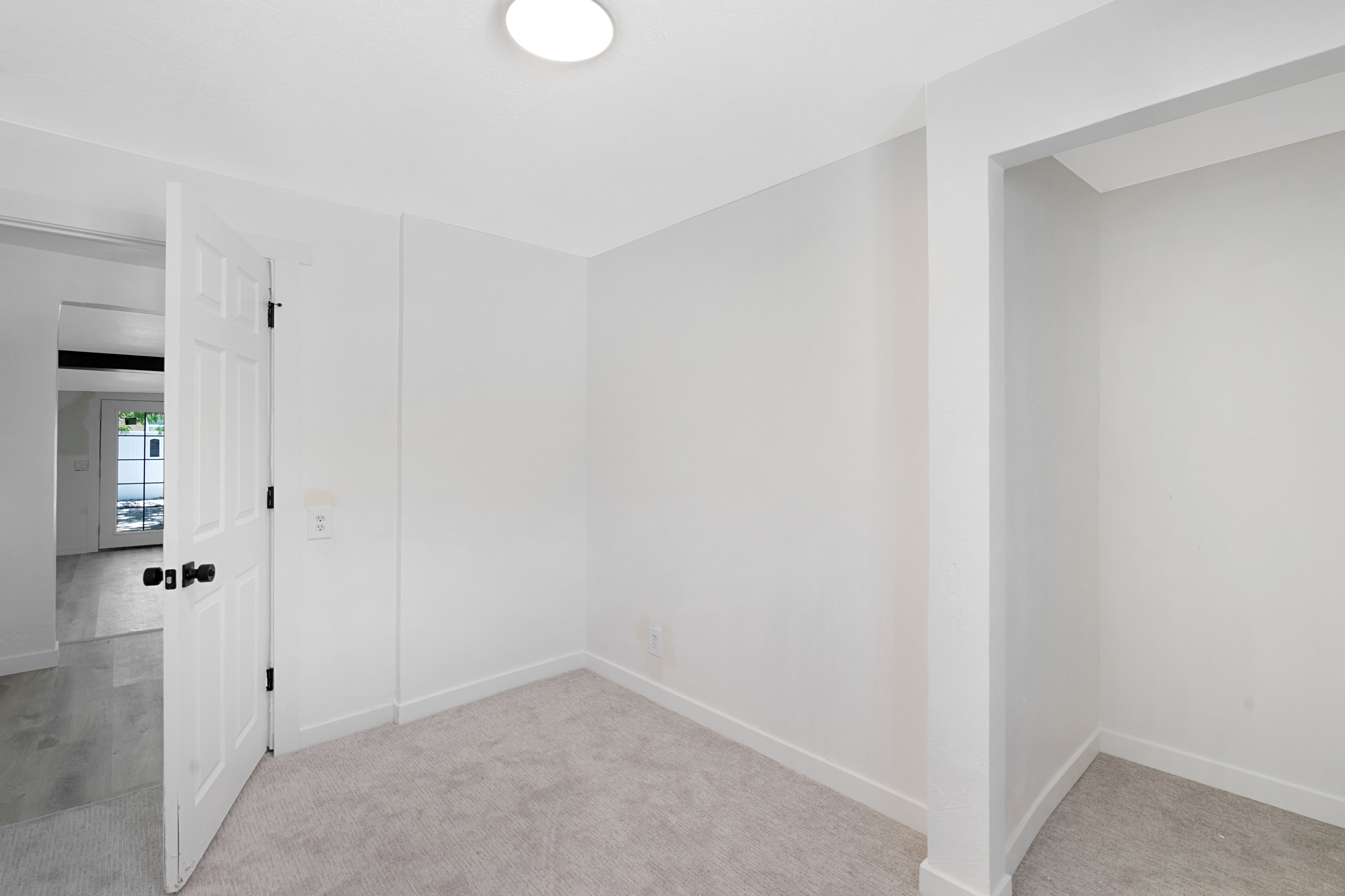 Carpeted interior room featuring white walls and trim