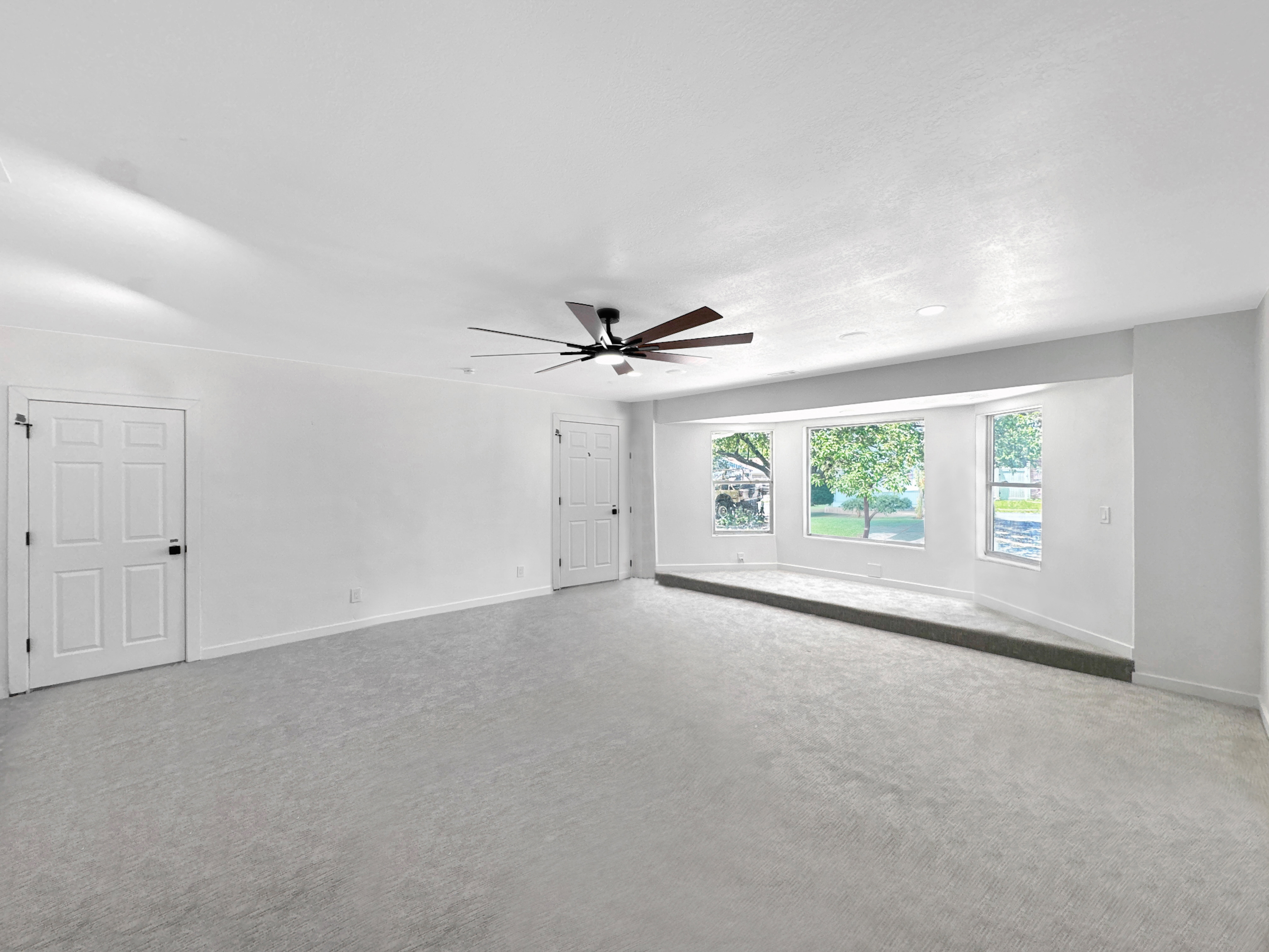 Spacious interior featuring light gray carpeting and white walls