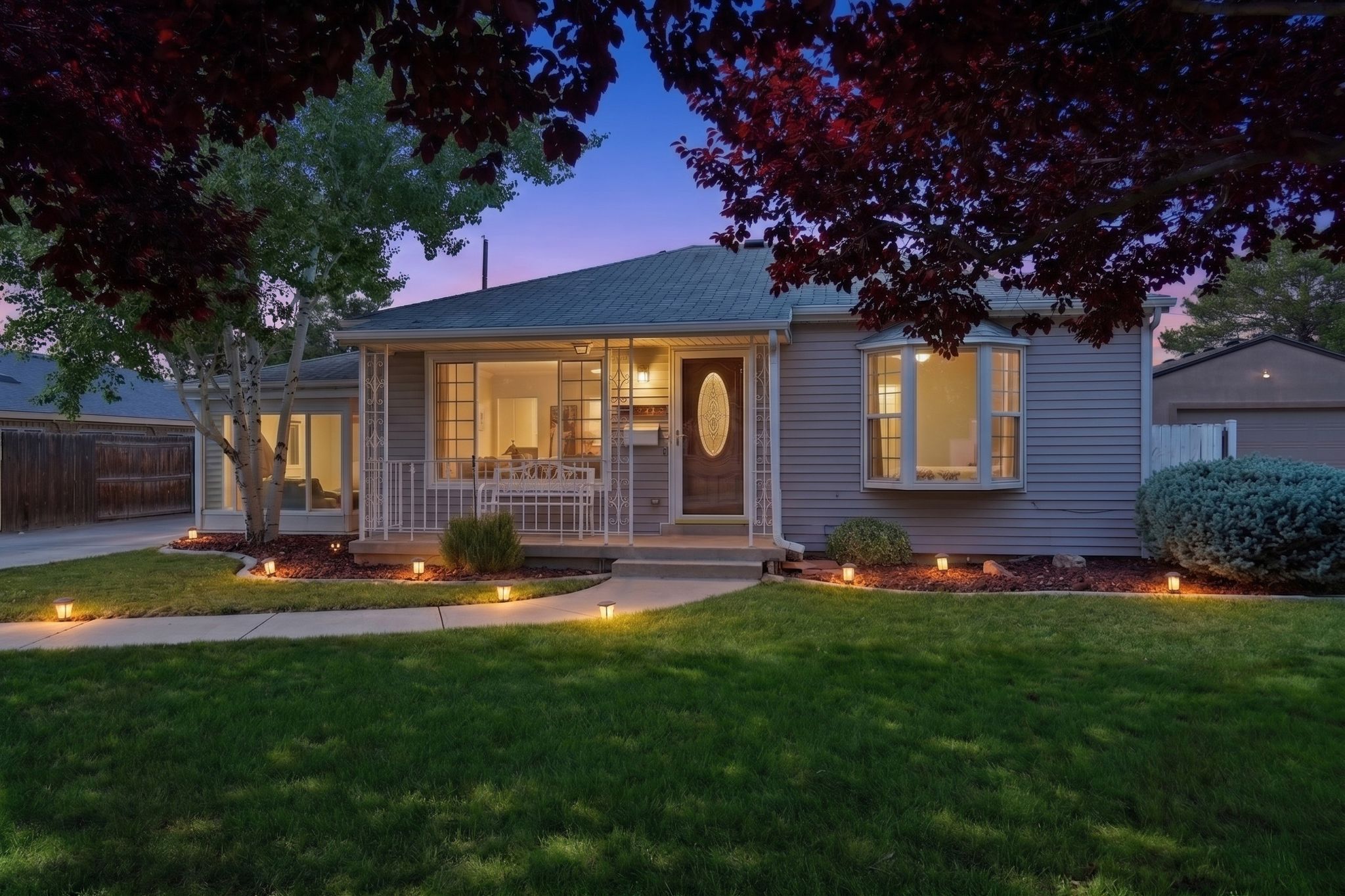 Single-story residence featuring light-colored siding and a covered front porch with white railings