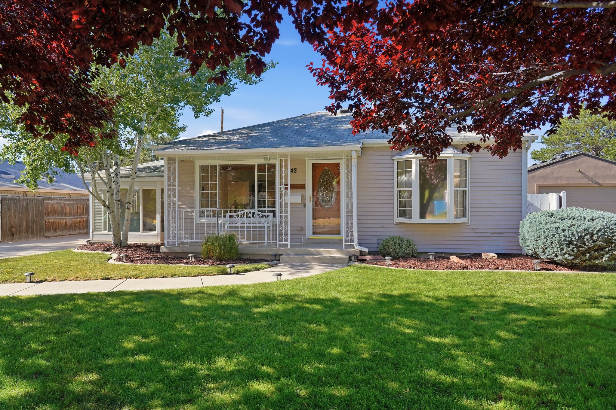 Single-story residence featuring light-colored siding and a covered front porch with white railings