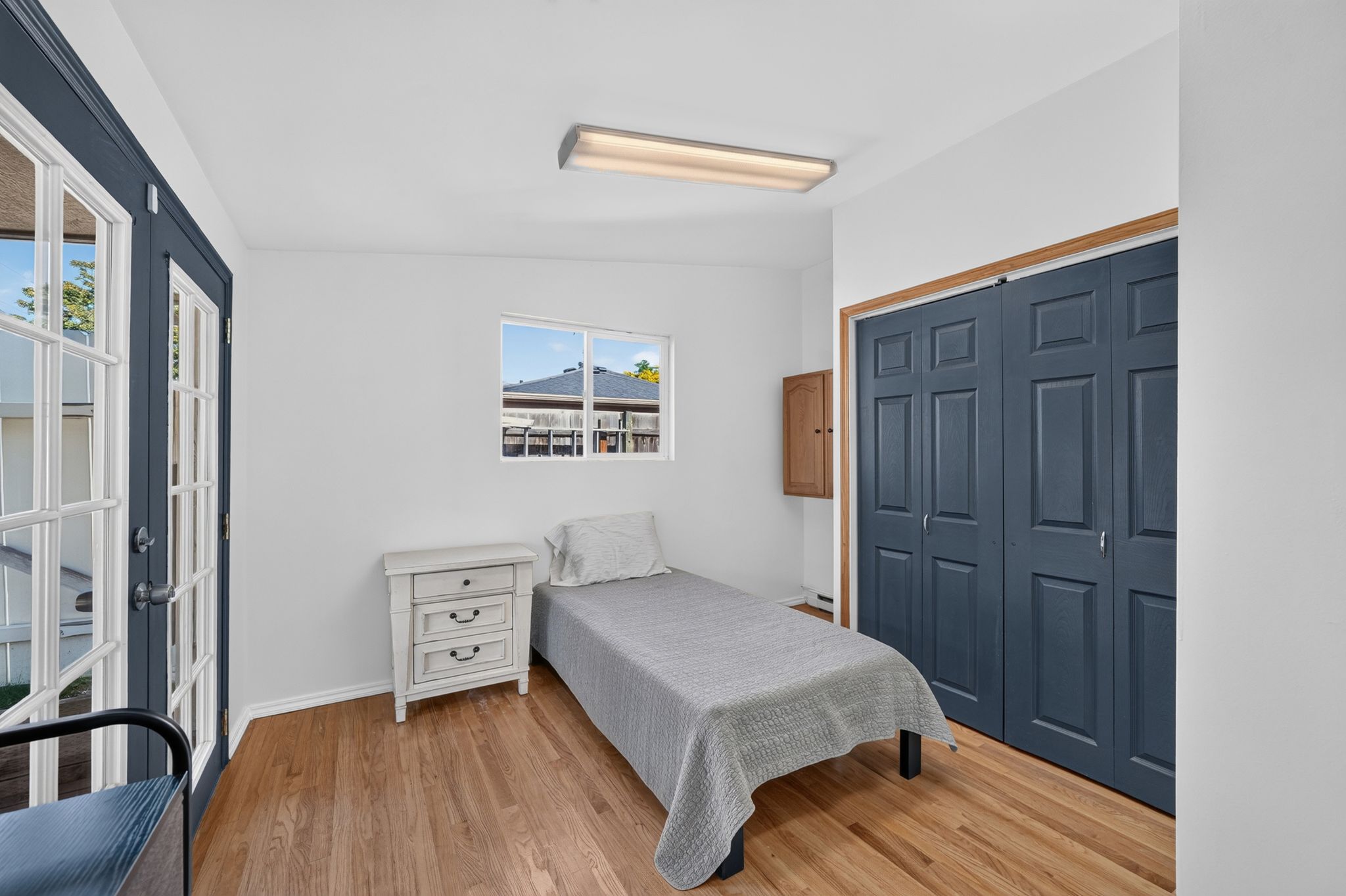 Room with wood-finish flooring and white walls