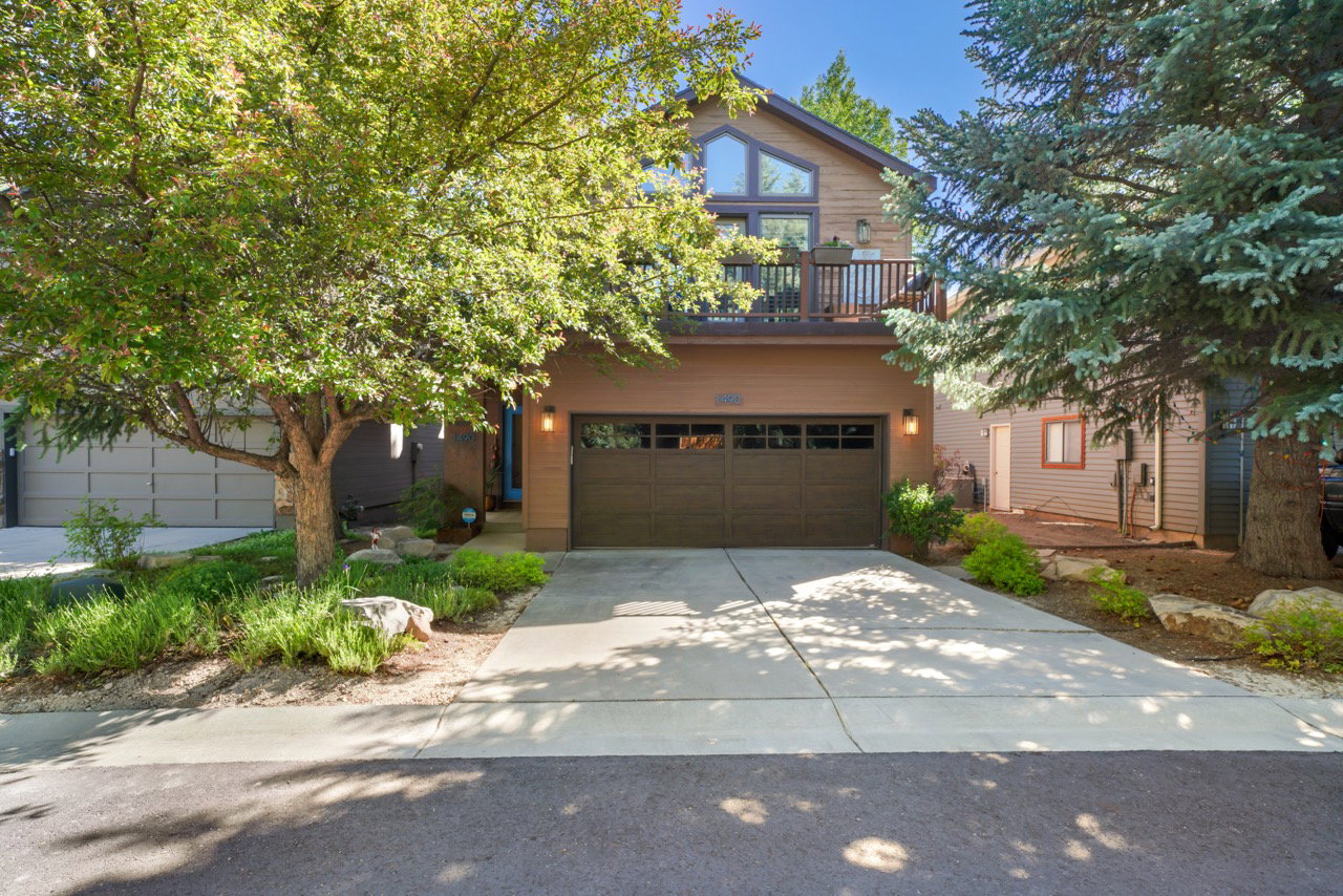 Contemporary exterior featuring a two-car garage, upper-level balcony, and large picture windows