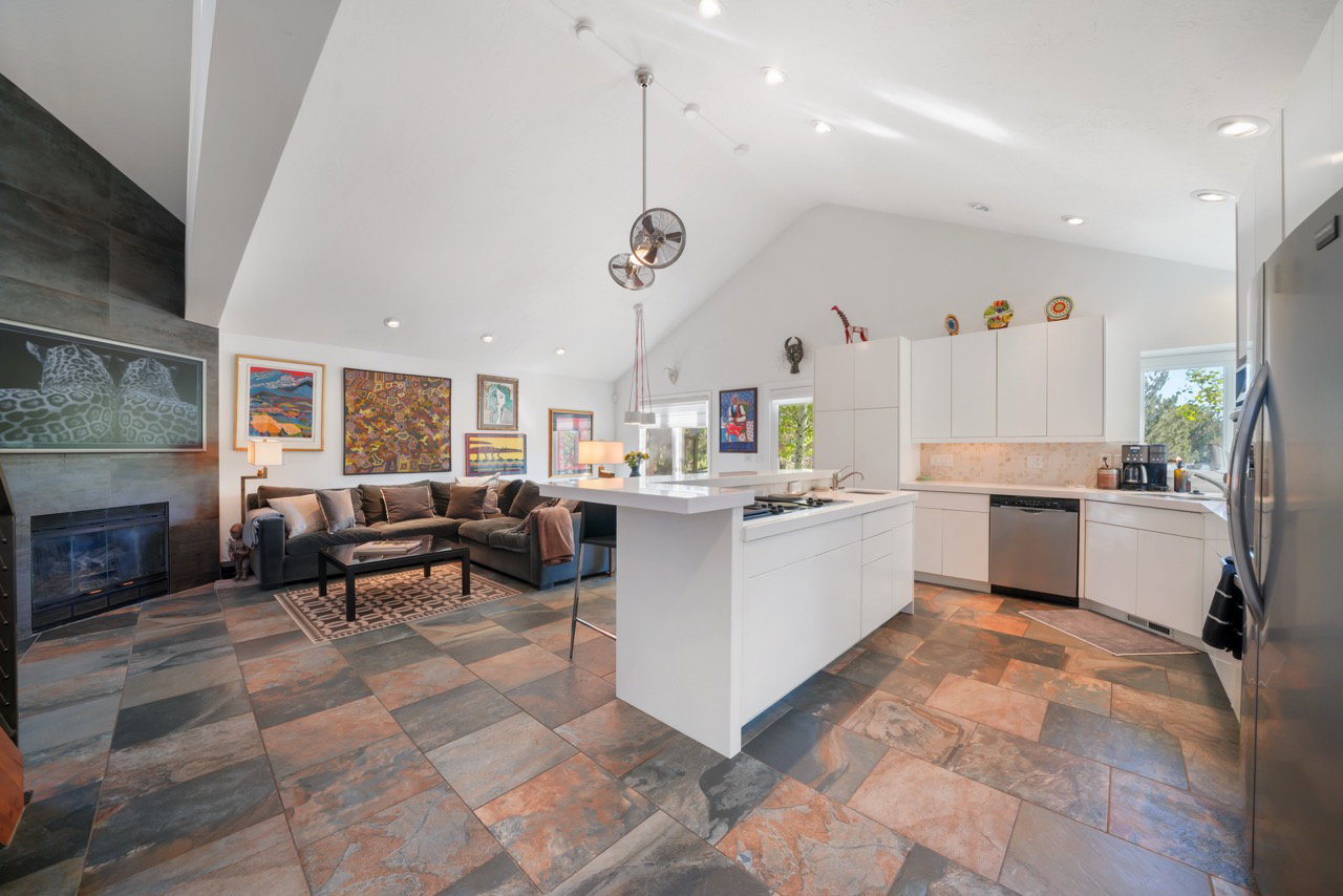 Open-concept living area with vaulted ceilings and large format slate flooring