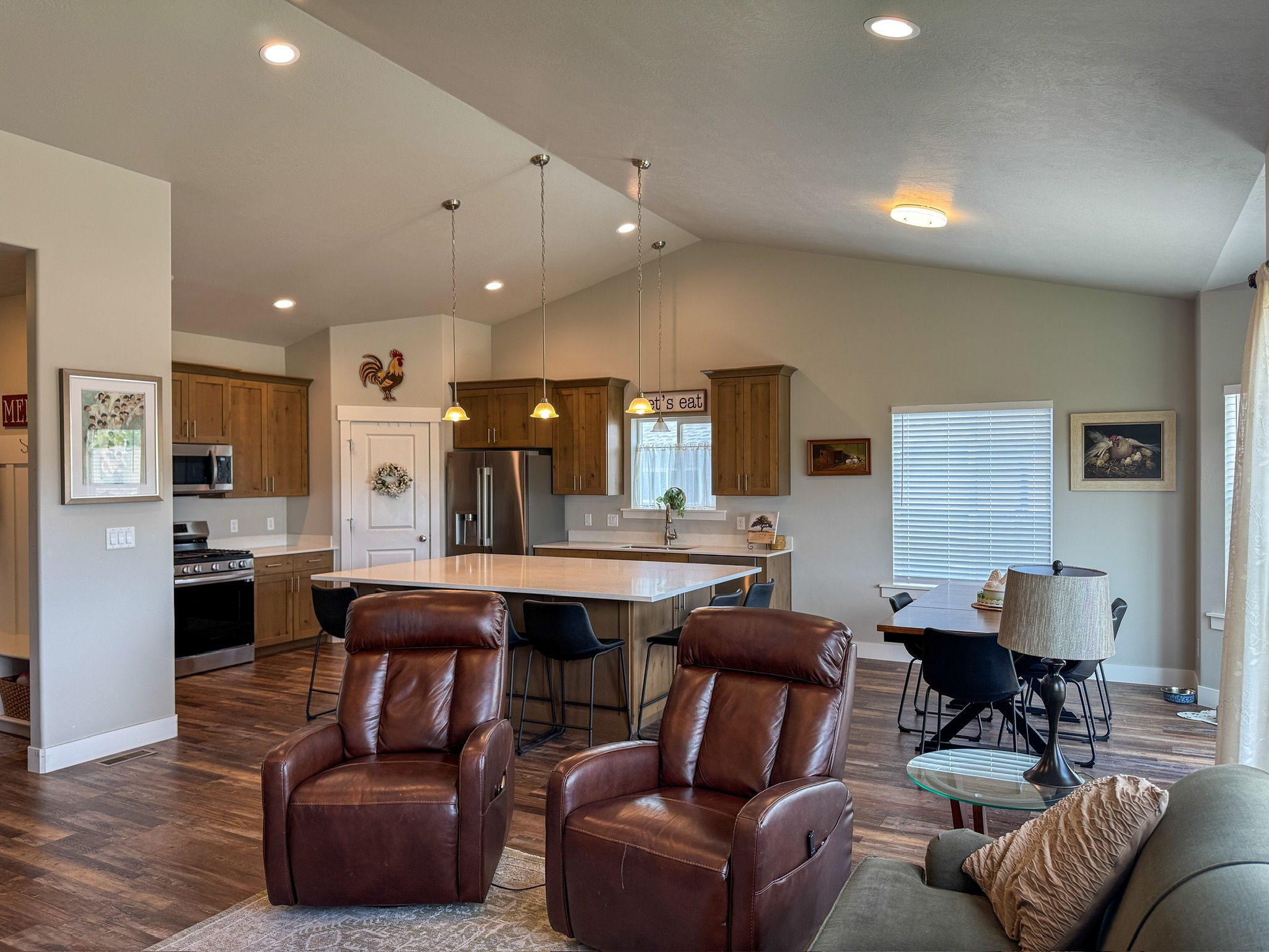 Vaulted ceilings enhance the open-concept design featuring wood-finish flooring throughout