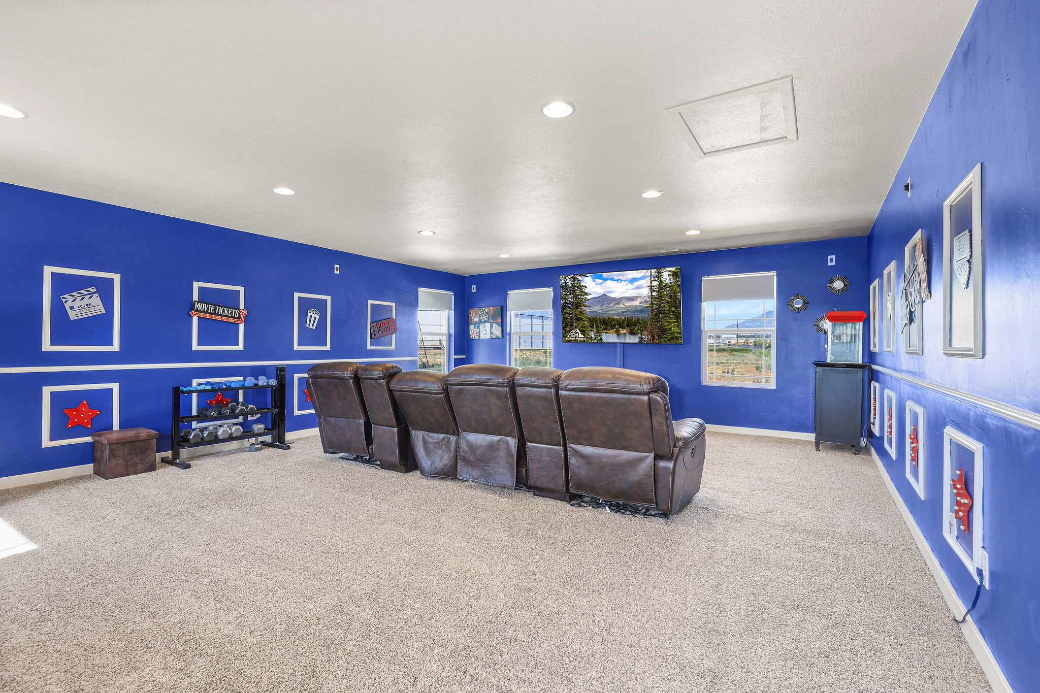 Spacious entertainment room featuring blue walls with white trim and recessed lighting