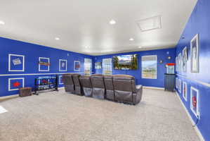 Spacious entertainment room featuring blue walls with white trim and recessed lighting
