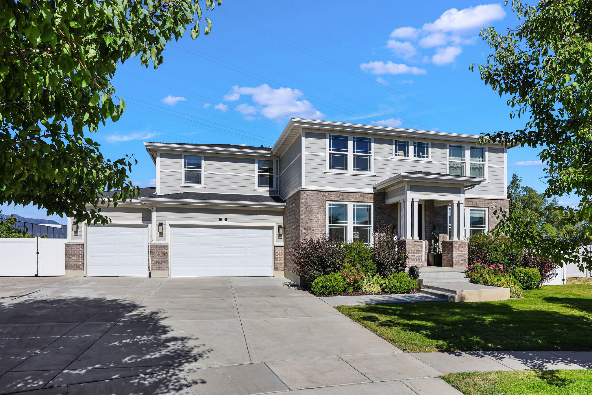 Traditional-style residence featuring a two-story design, a covered entry with columns, and a 3-car garage